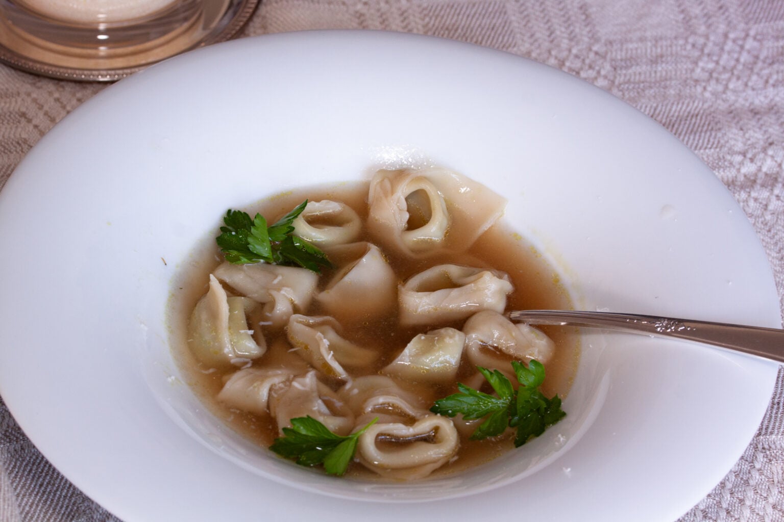 A copious number of tortellini served in a white soup plate