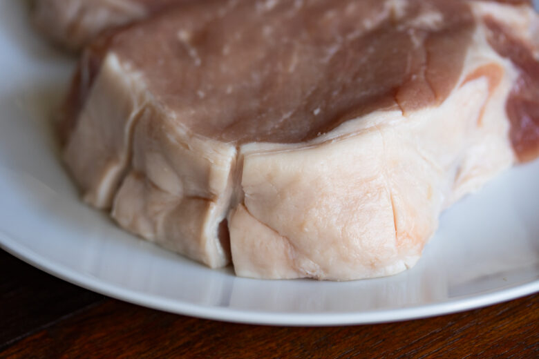 bone in pork chop with fat bard slit