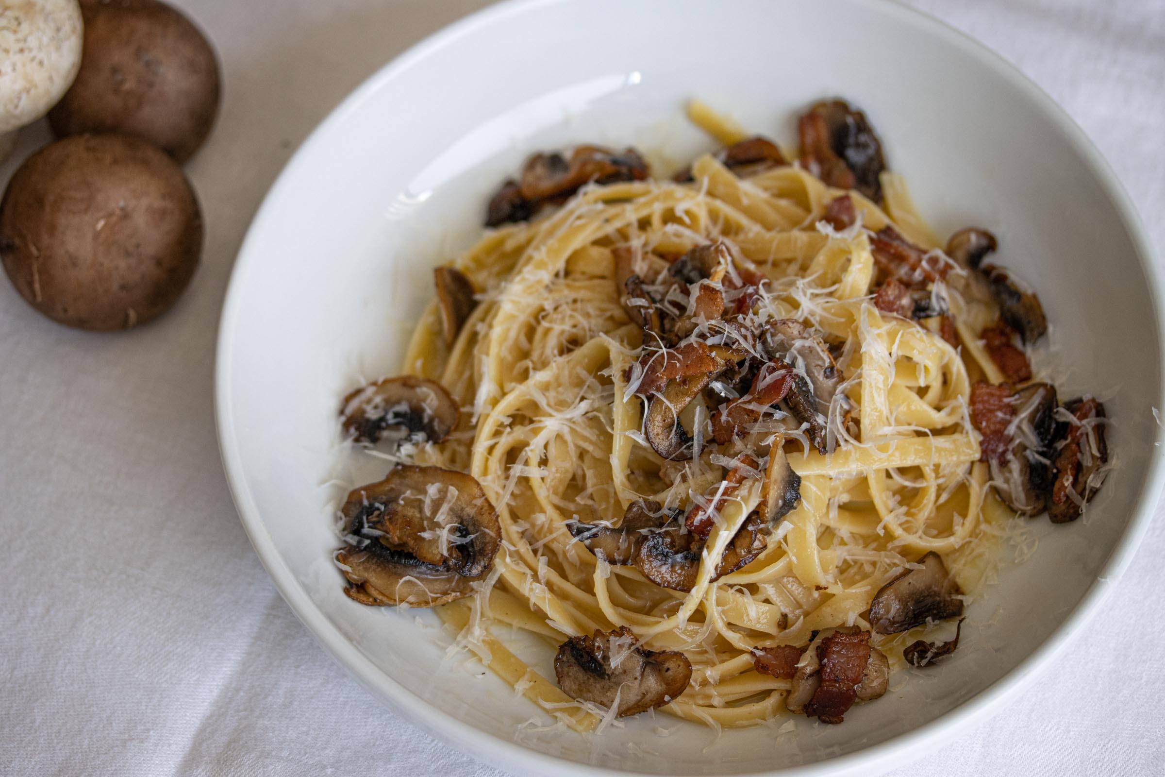 linguine, bacon, mushroom in a white plate