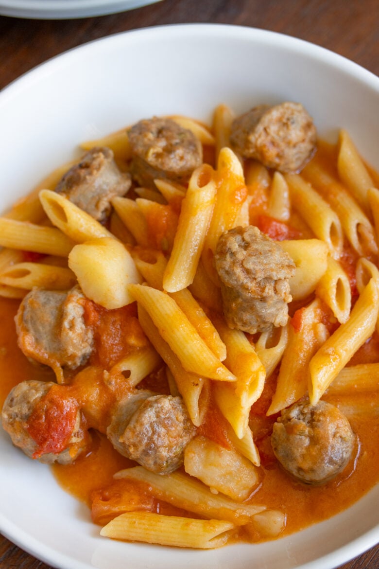 Penne with Sausage, Tomatoes and Potatoes Penne Pasta with Sausage and Tomatoes Ingredients in a serving white plate