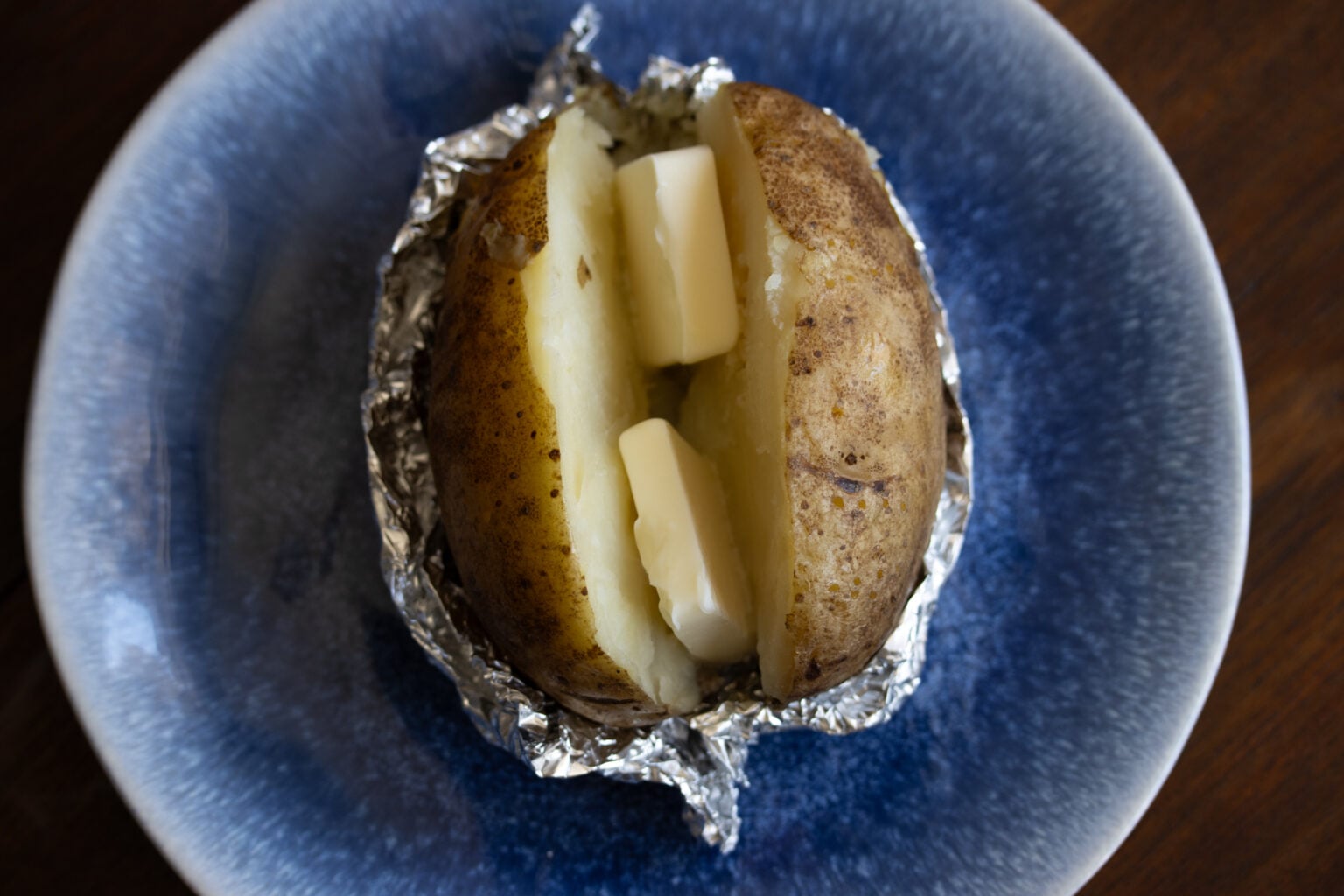A potato sliced with butter added.