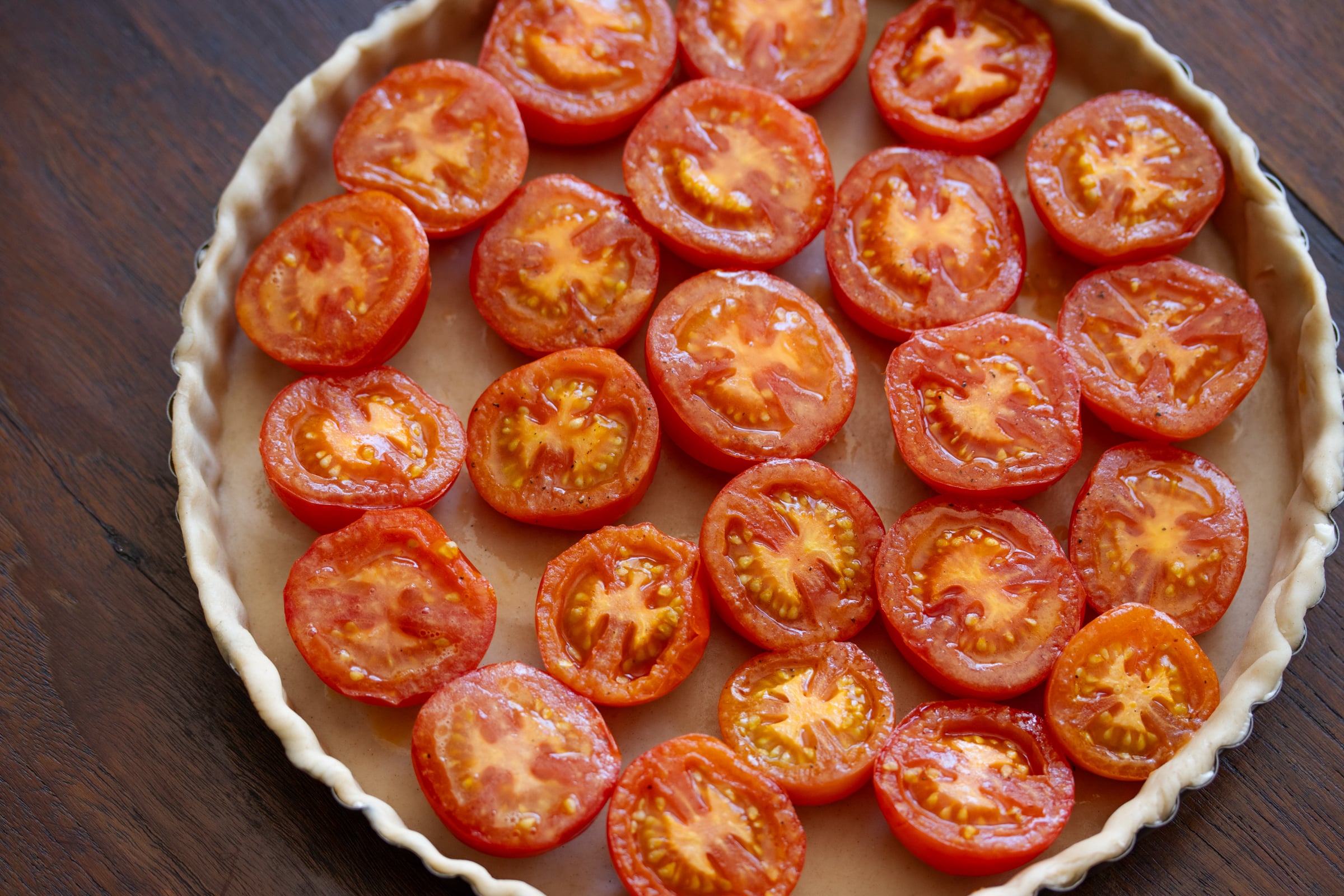 Tomato halves placed into the quiche mold.