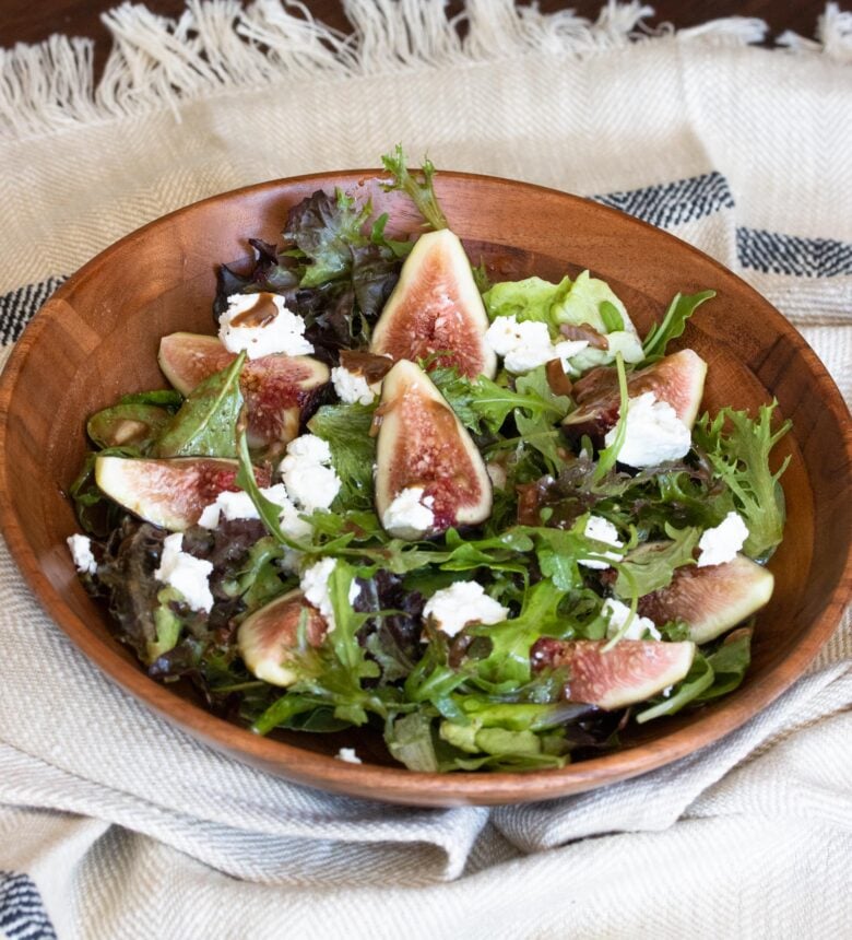 fig salad with goat cheese in a wooden serving plate