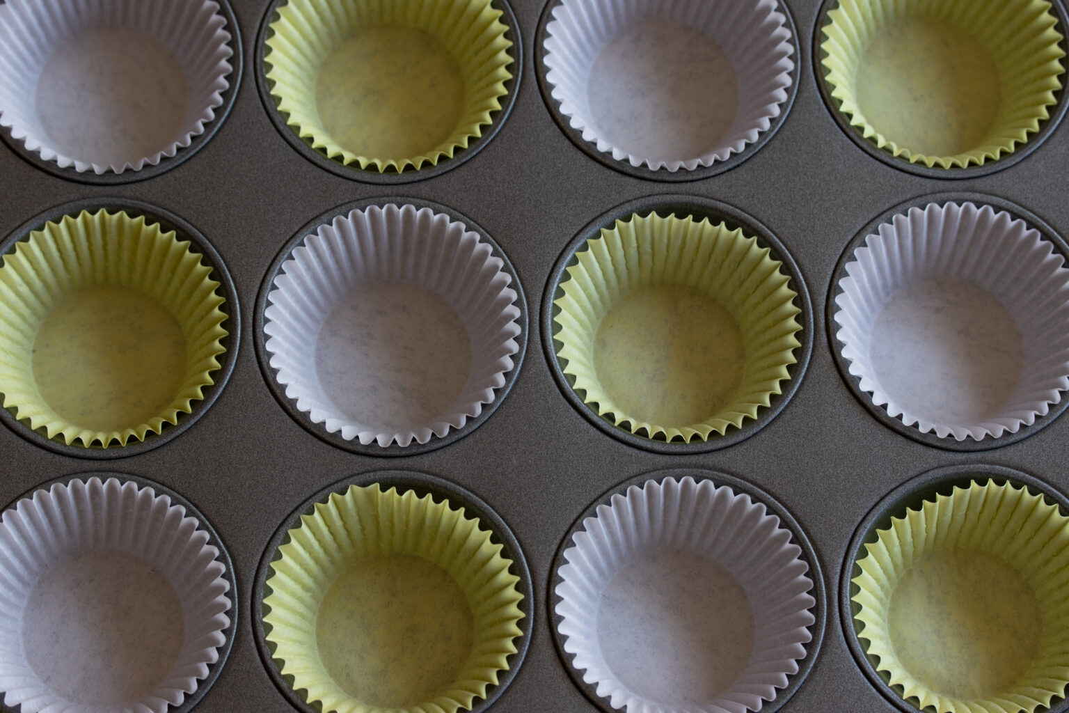 Muffing paper cup lining the muffing tin.