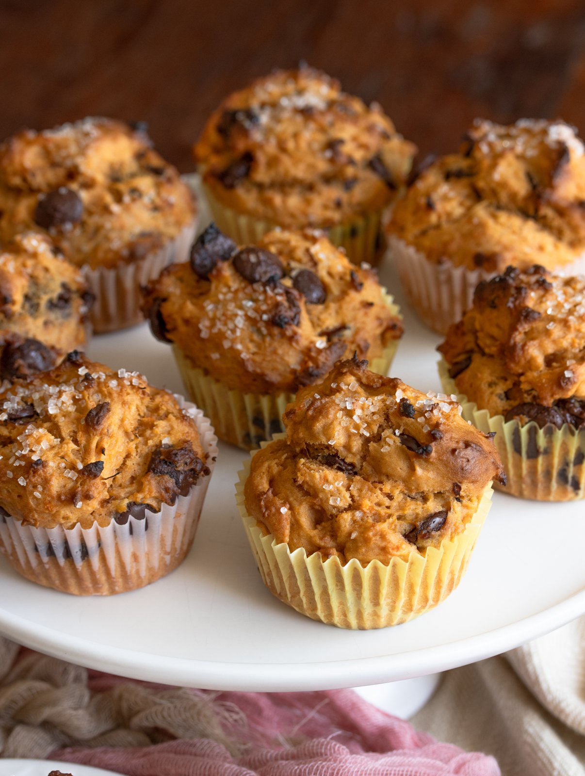 Several completed muffins on a white cake stand.
