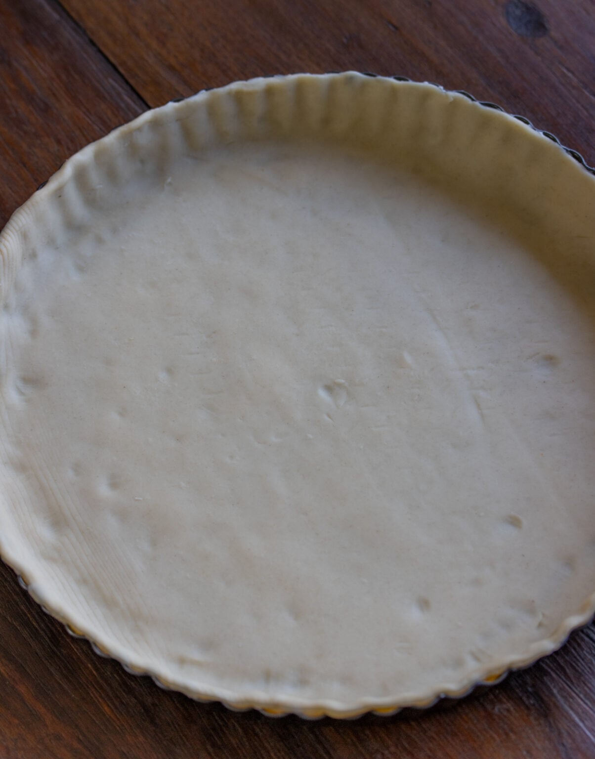 Pastry dough rolled out on a baking dish.