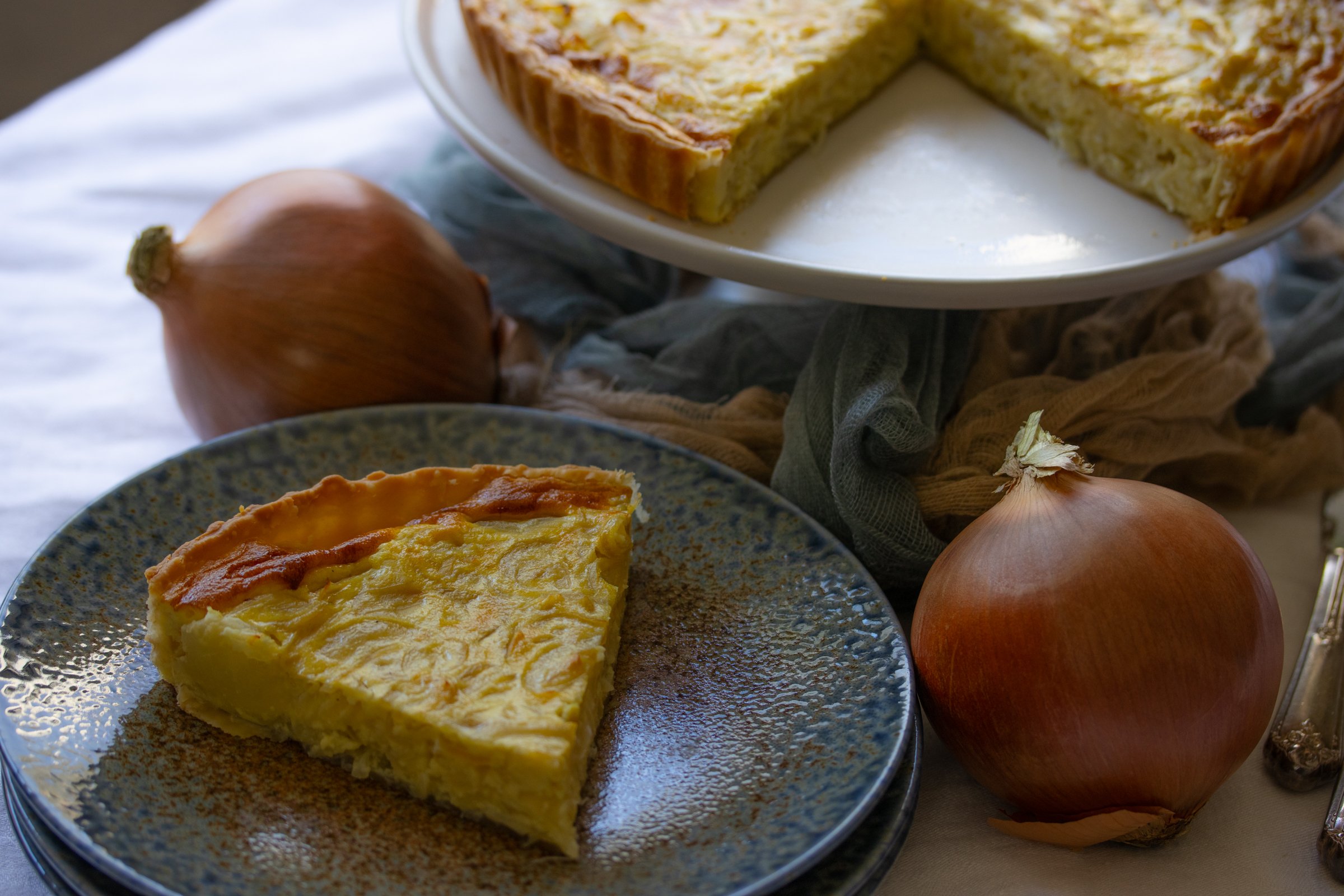 slice on French onion tarte on a plate