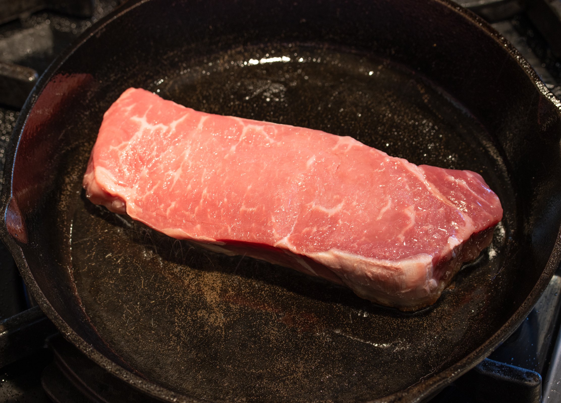 placing the steak in a hot skillet