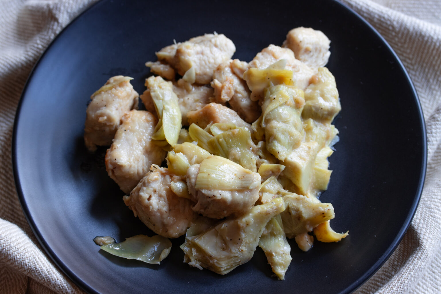 Chicken and Artichokes in a black dish