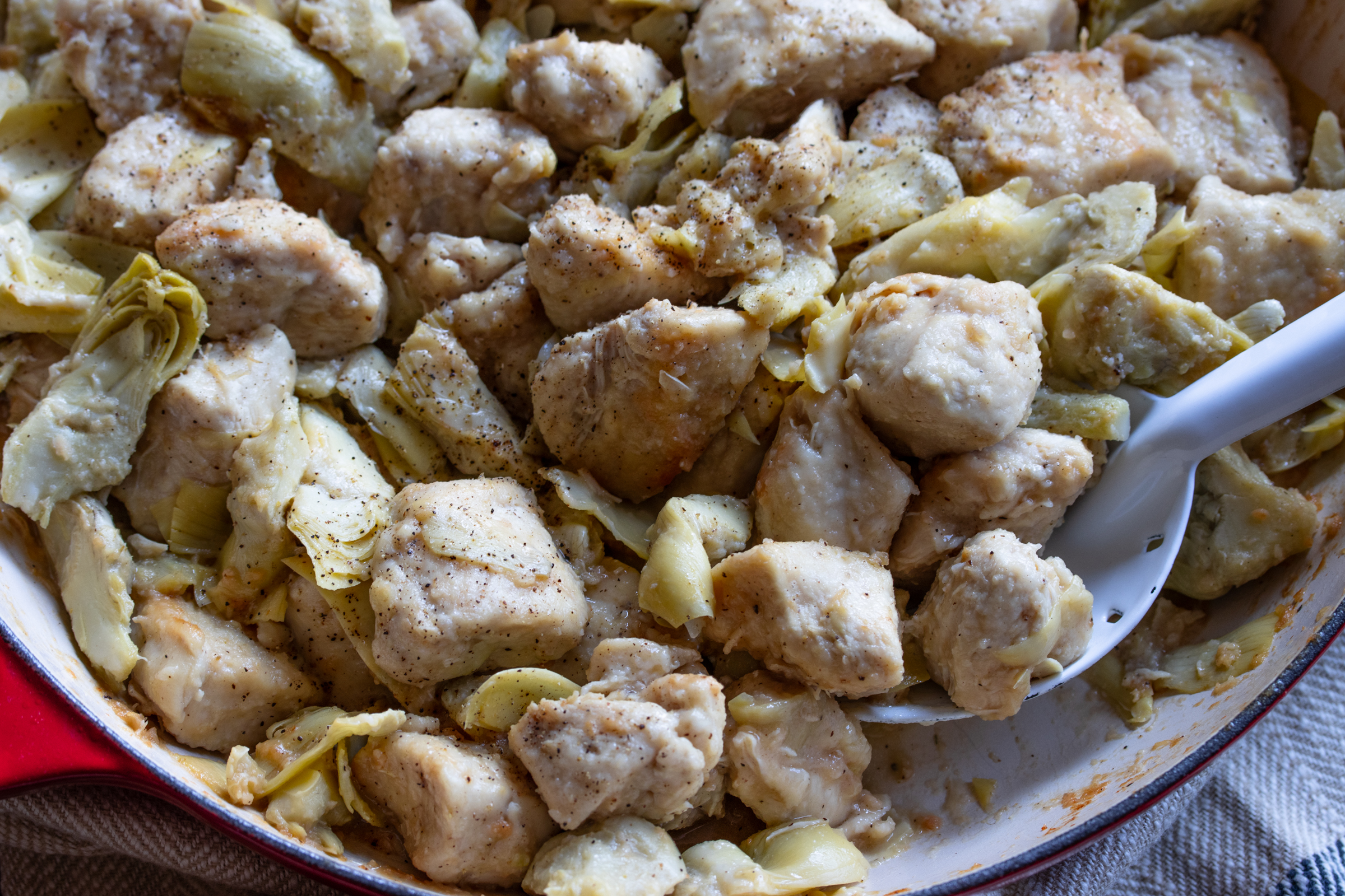 finished chicken and artichokes with white spoon