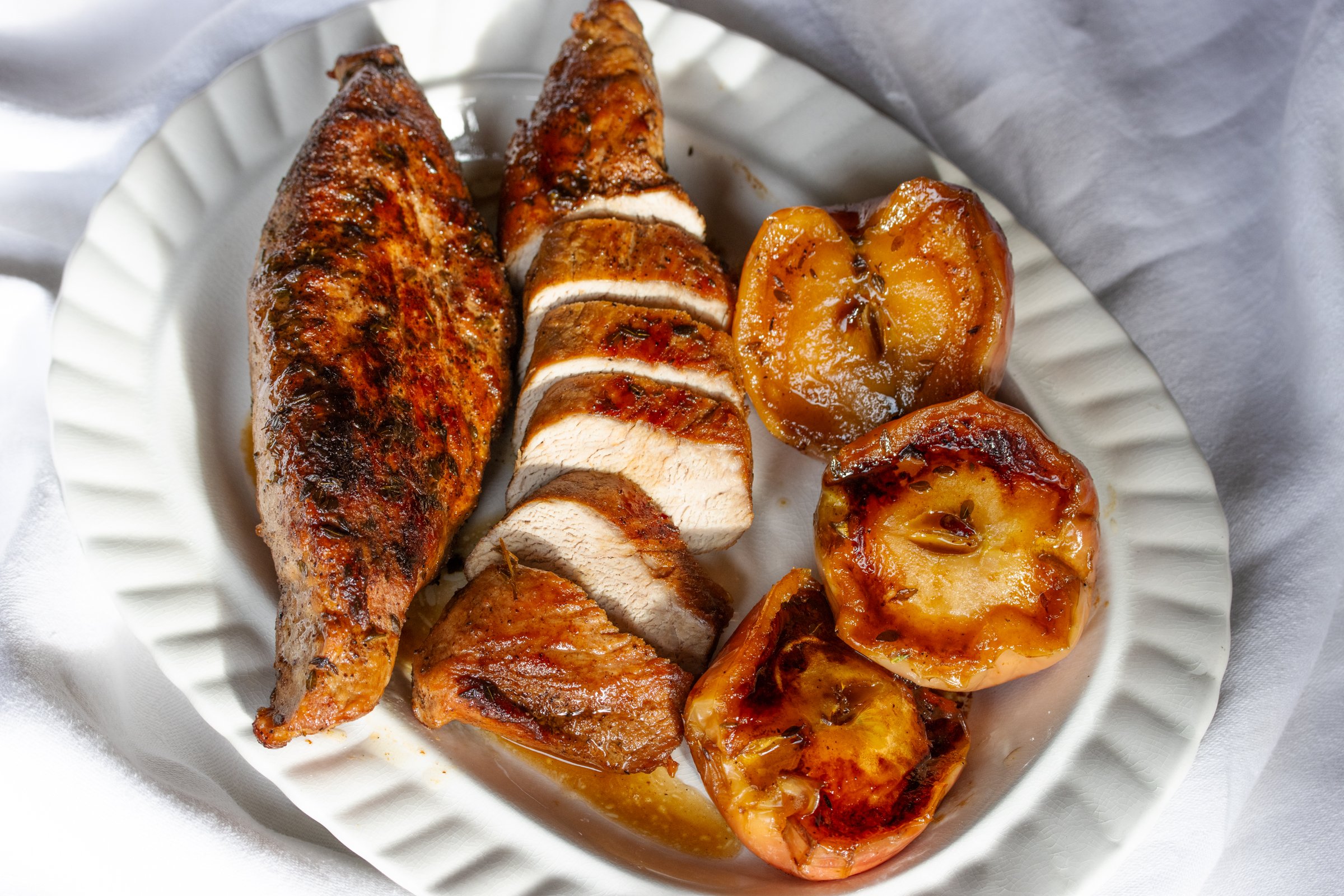 The tenderloin is sliced and served with apples.