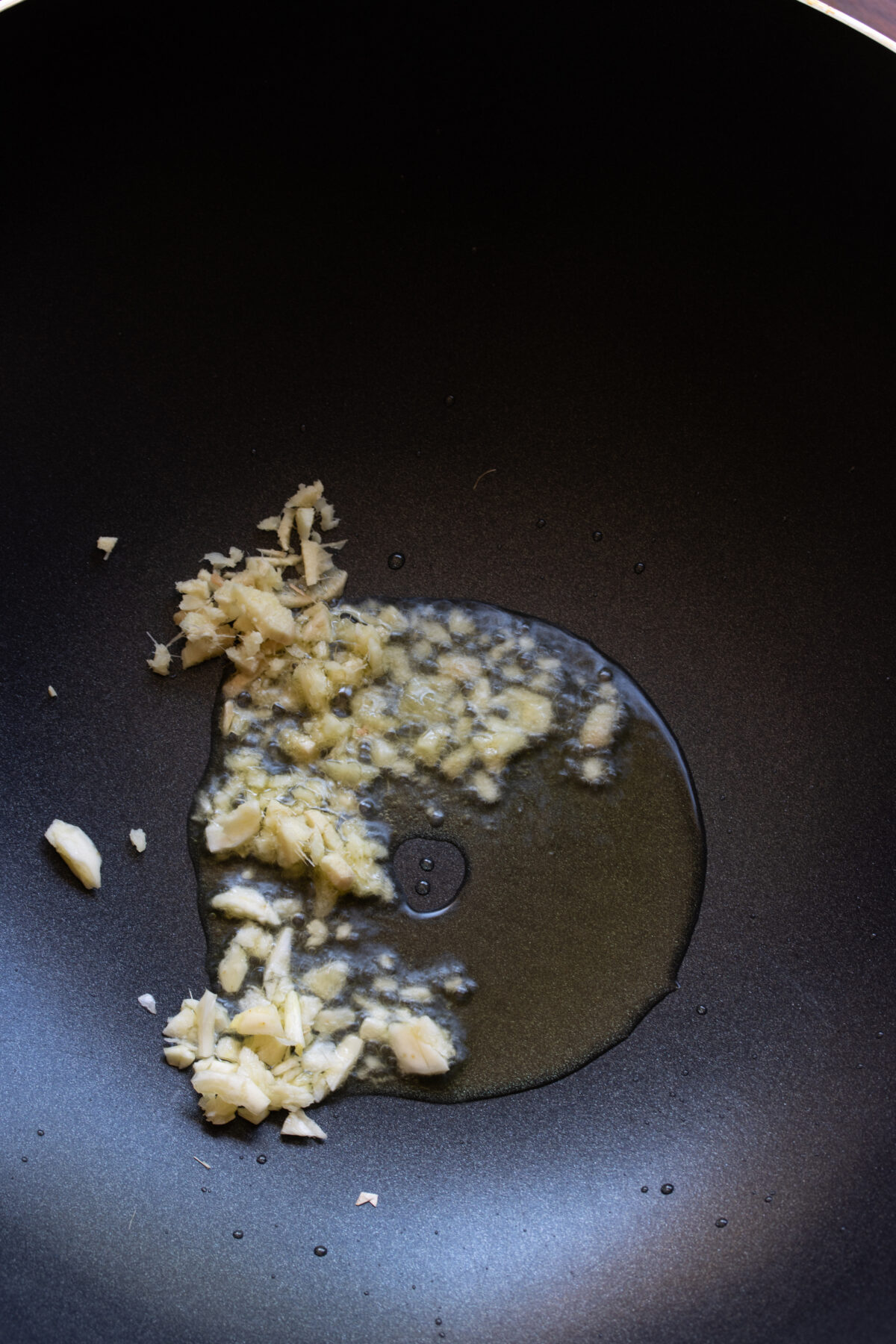 IN a wok, garlic and ginger are added to the hot oil.