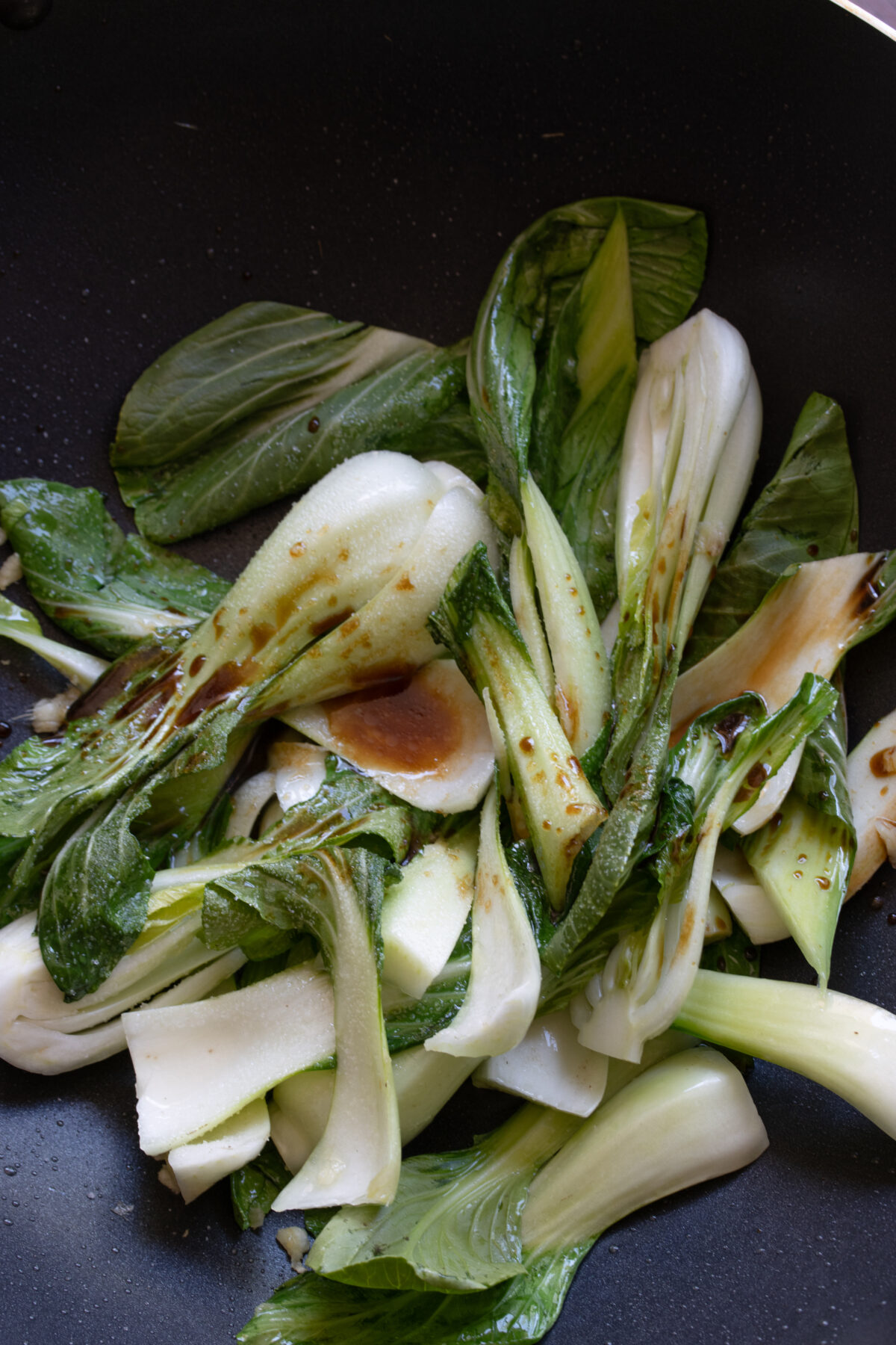 Sugar, stock, sugar, soy sauce are added to the cooked bok choy.