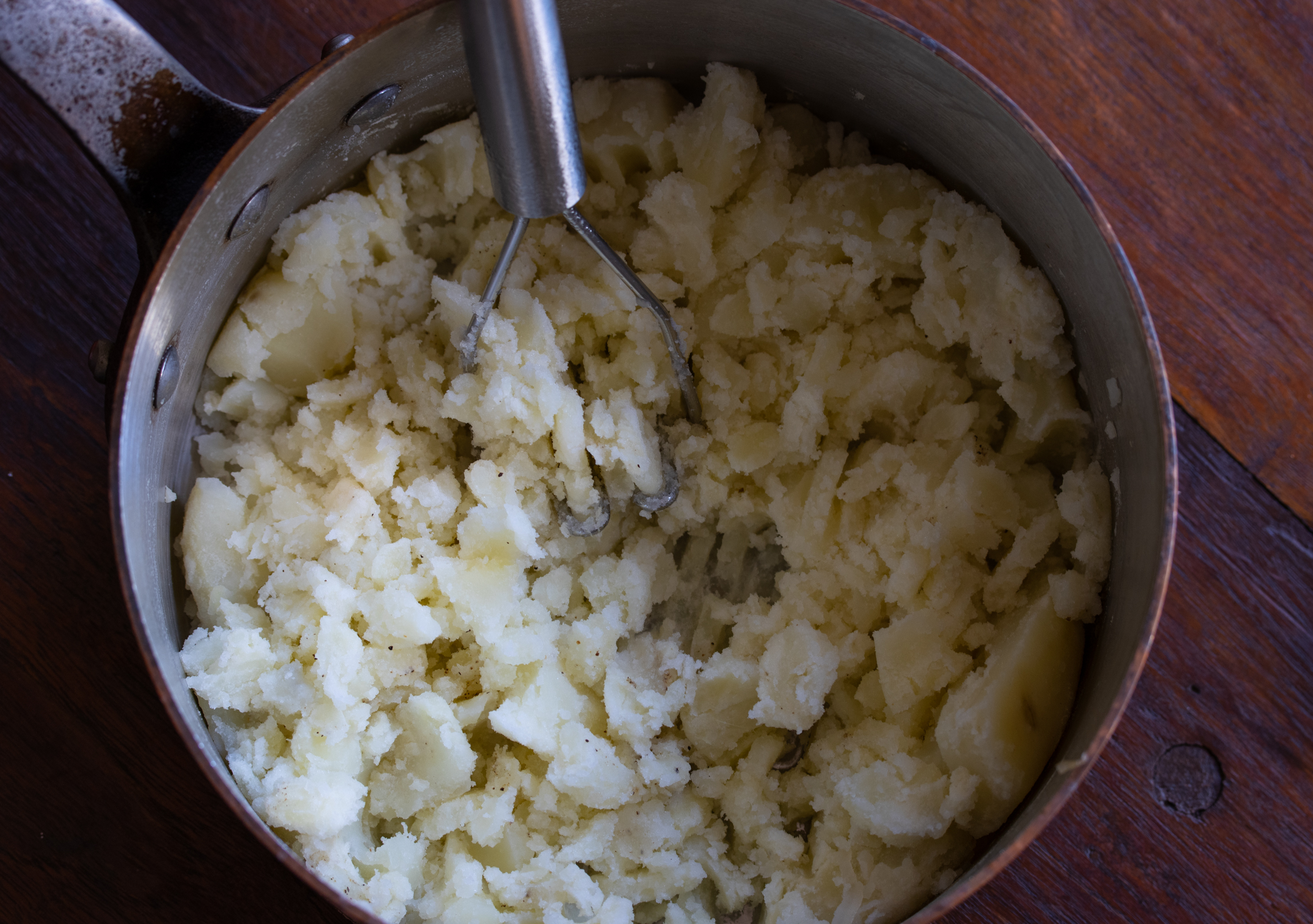 mashing the potatoes to desired consistency