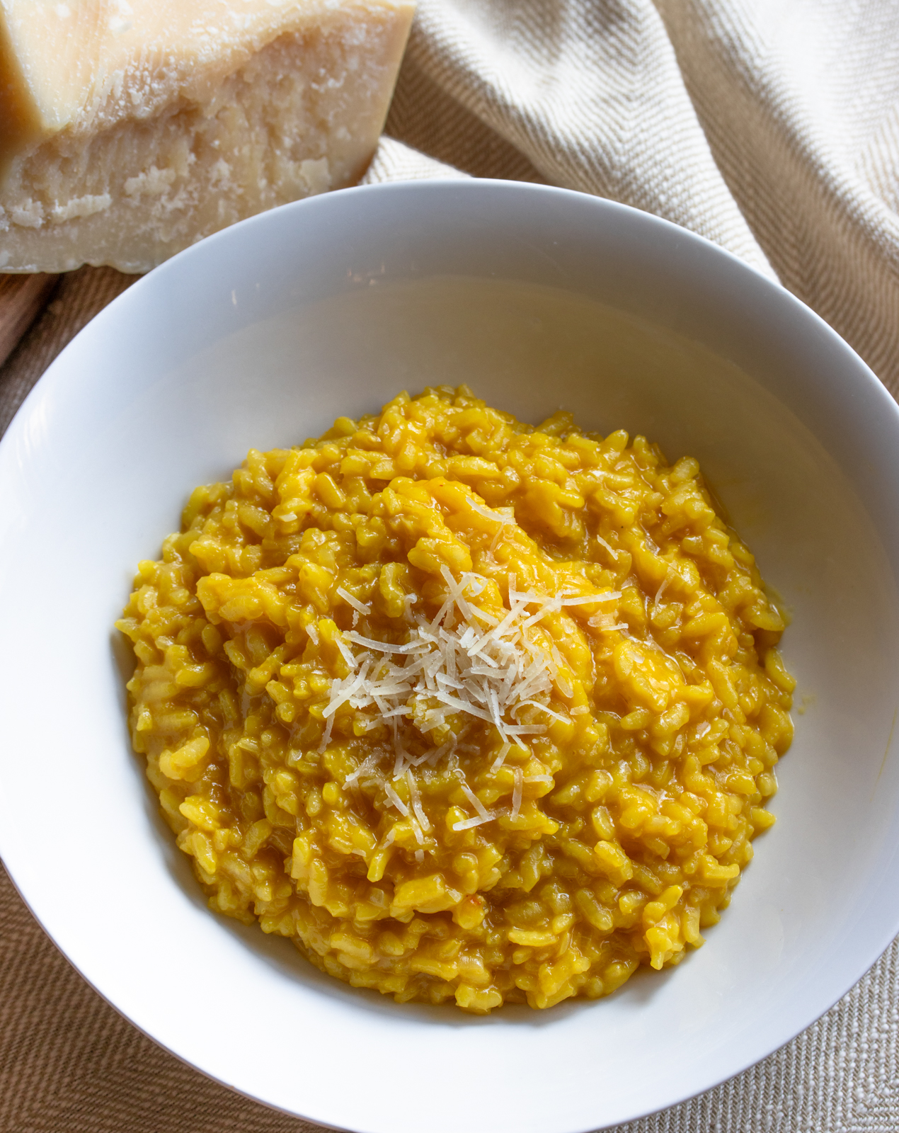 risotto with freshly grated parmigiano in a white plate