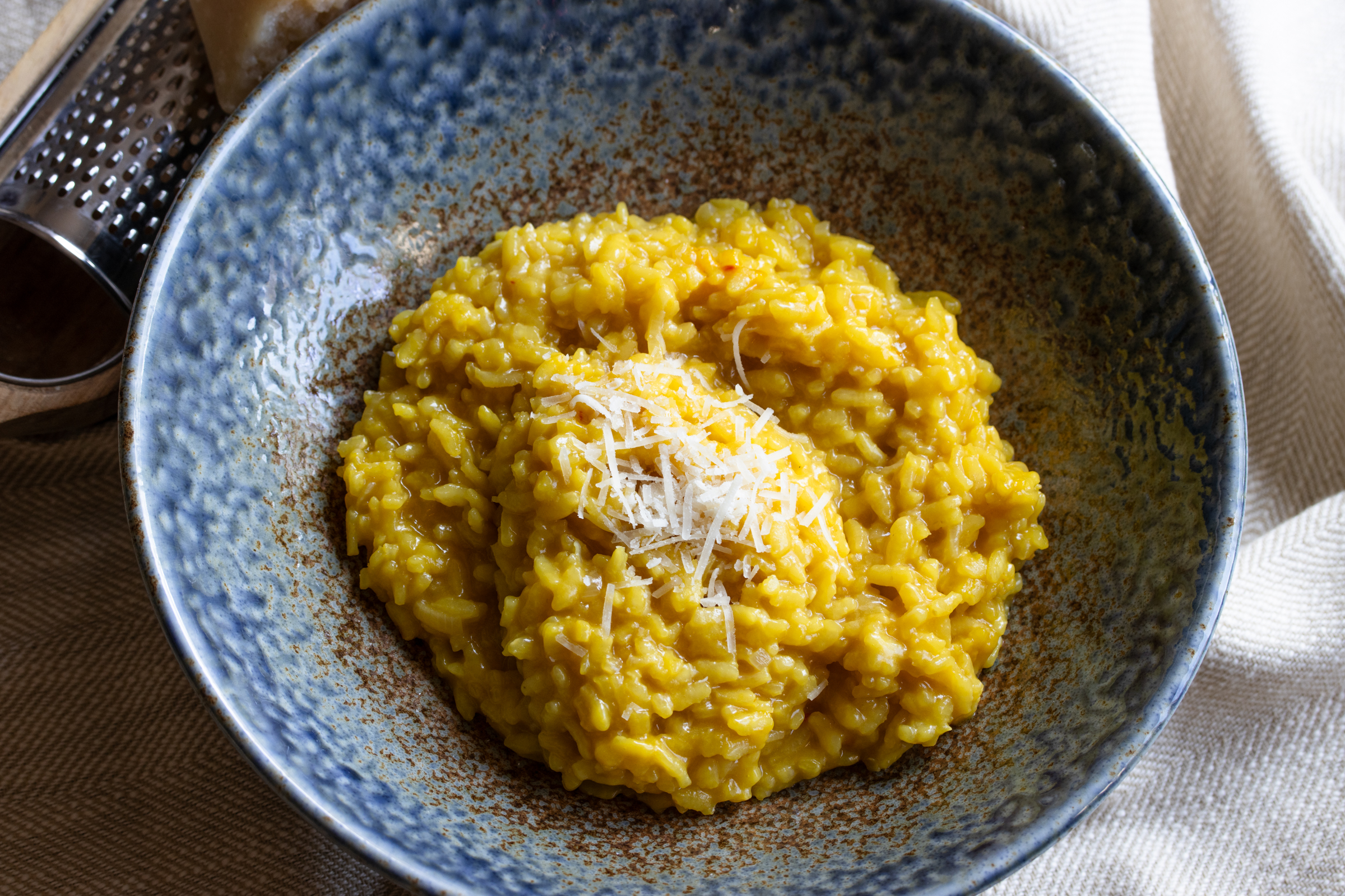 risotto milanese in a blue serving plate