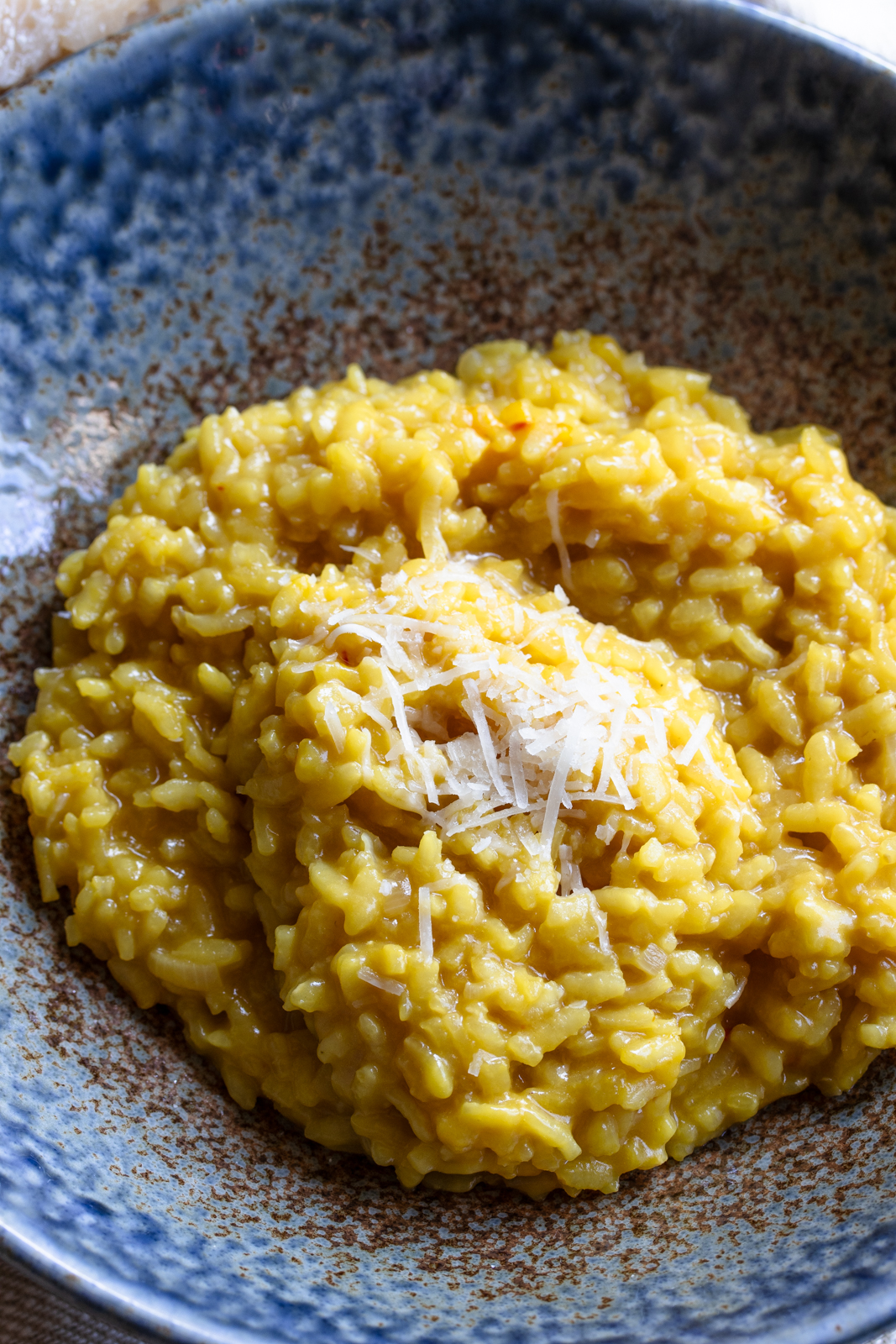 risotto alla milanese in a blue serving dish