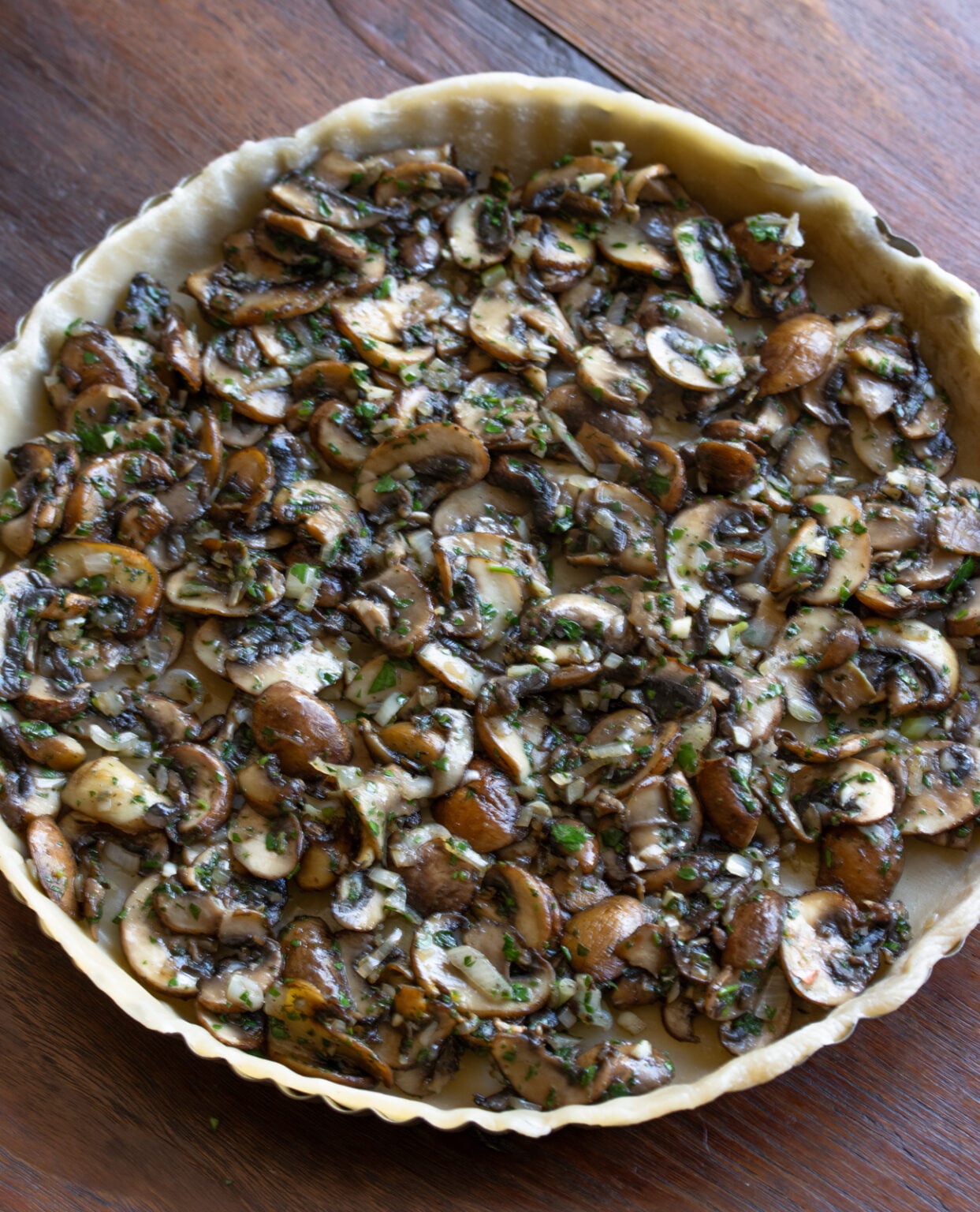 mushrooms at the base of the pie ready to have the cream egg mxiture poured over it