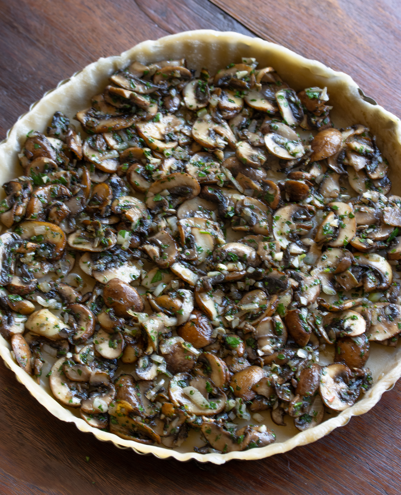 mushrooms at the base of the pie ready to have the cream egg mxiture poured over it
