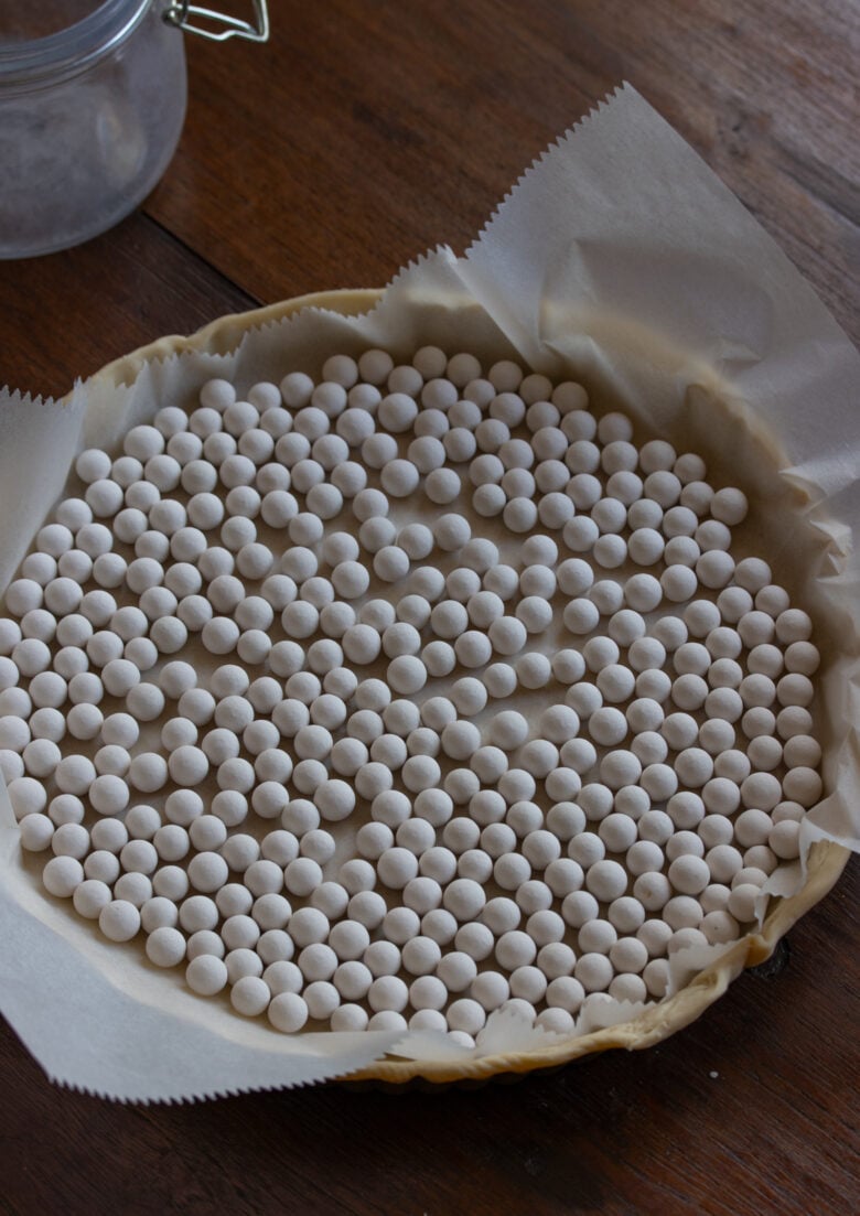 pie dough in the mold with pie weight