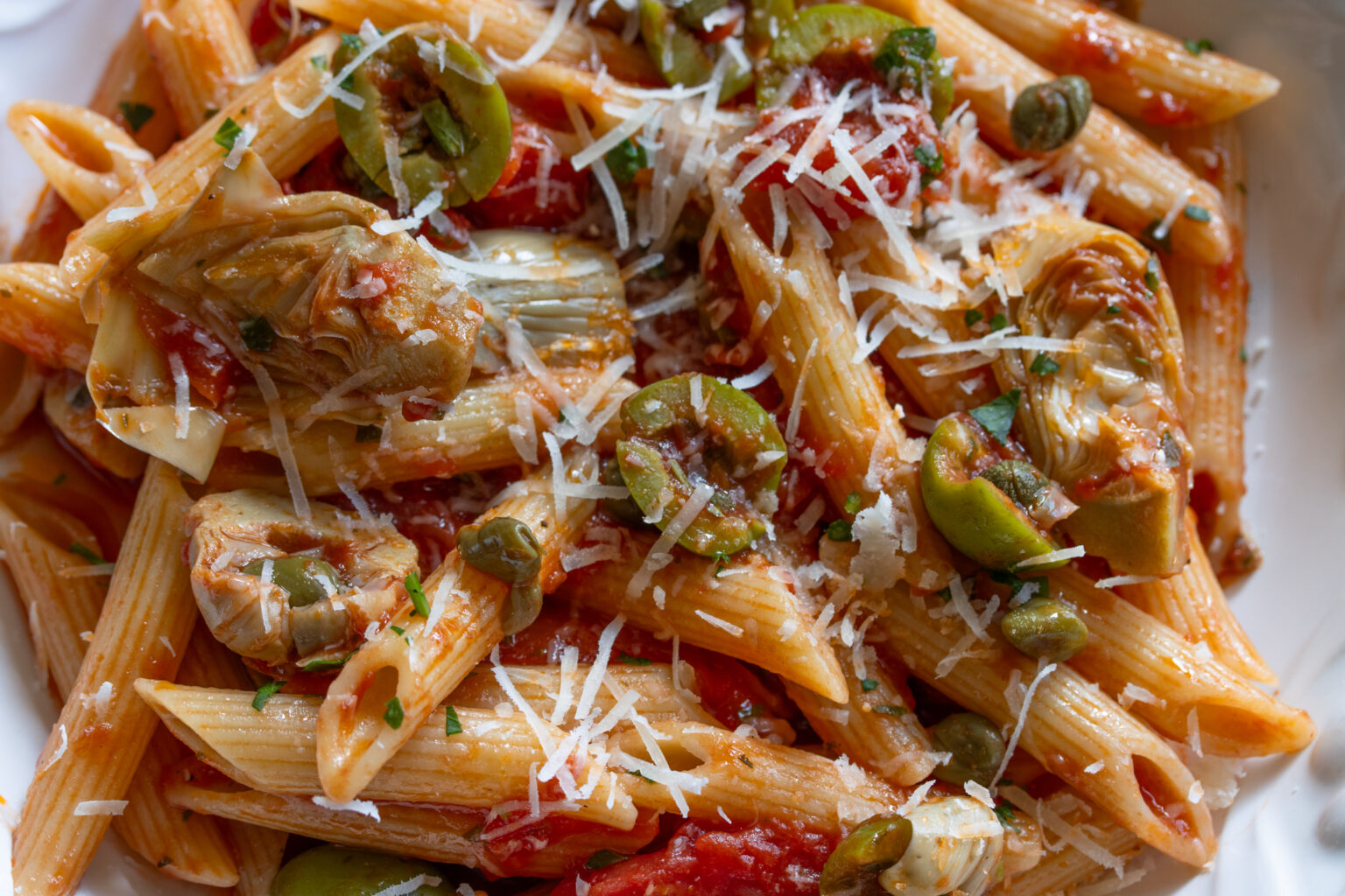 penne with tomatoes, olives, and artichokes close up