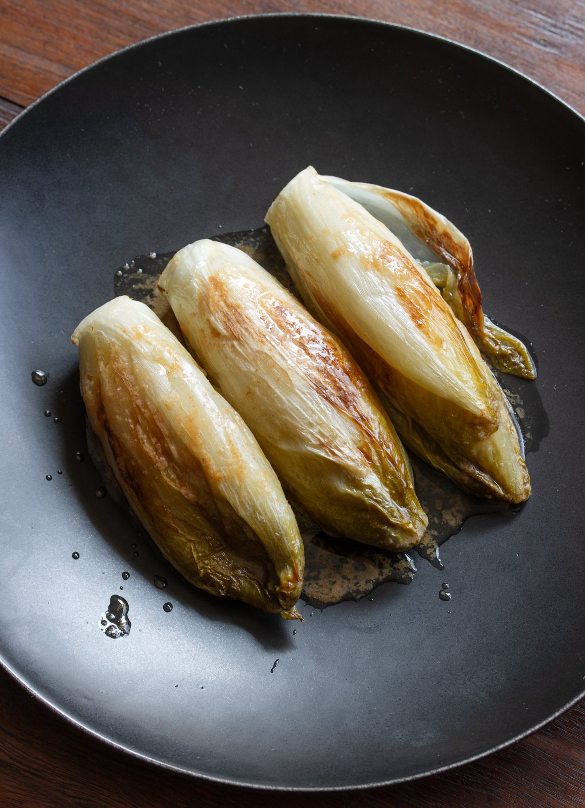 braised endives served in a black plate