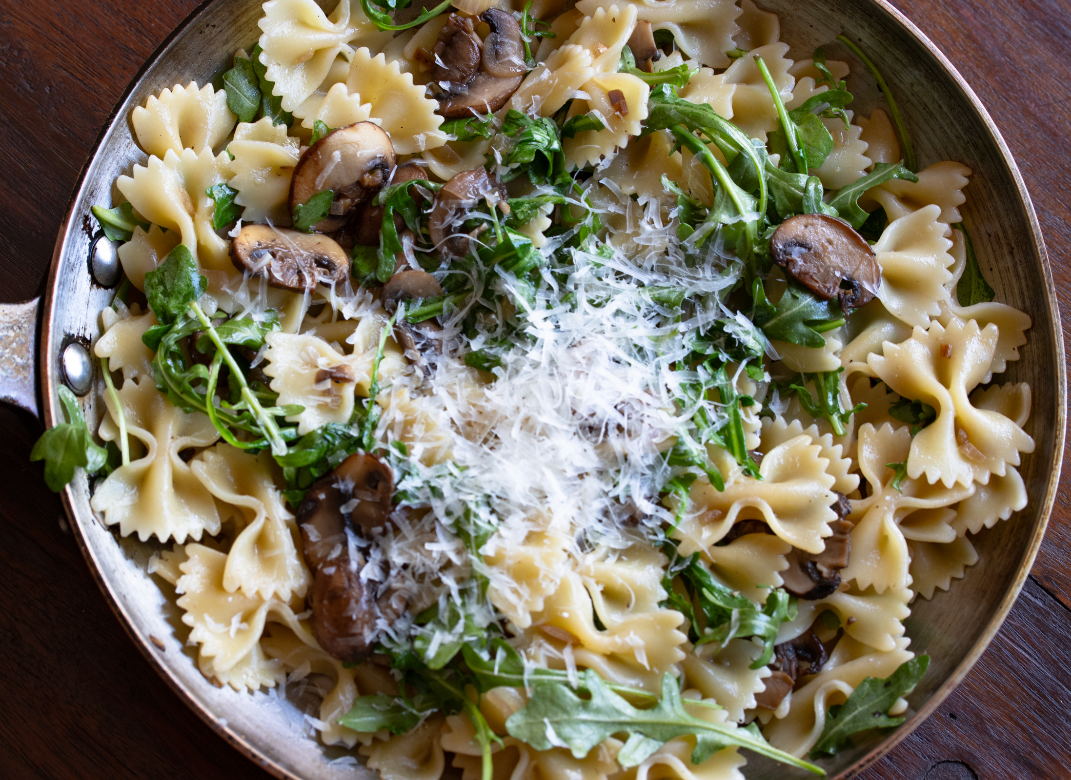 pasta all mixed with mushroom sauce and parmesan cheese added to it