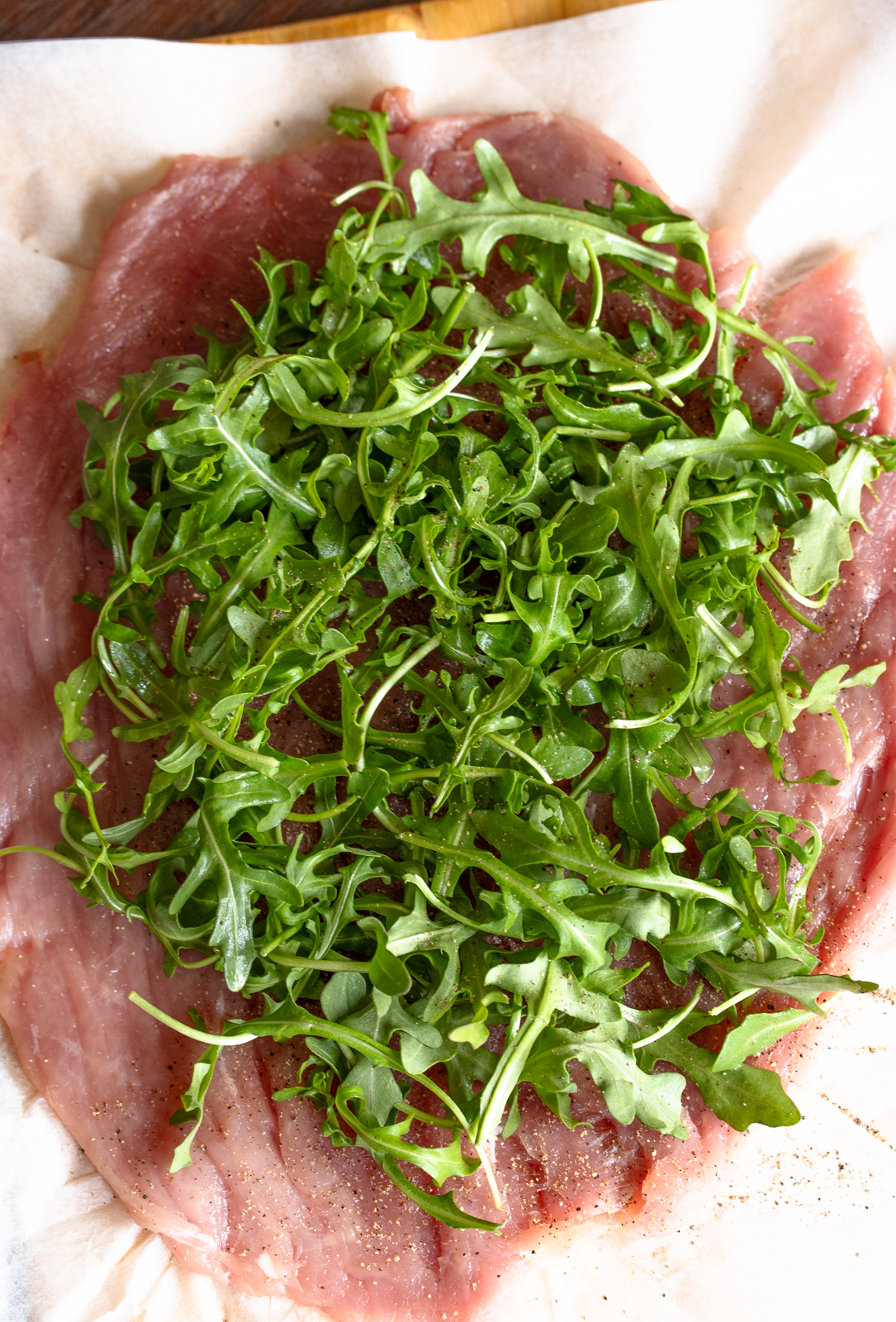 arugula salad spread over the pork tenderloin