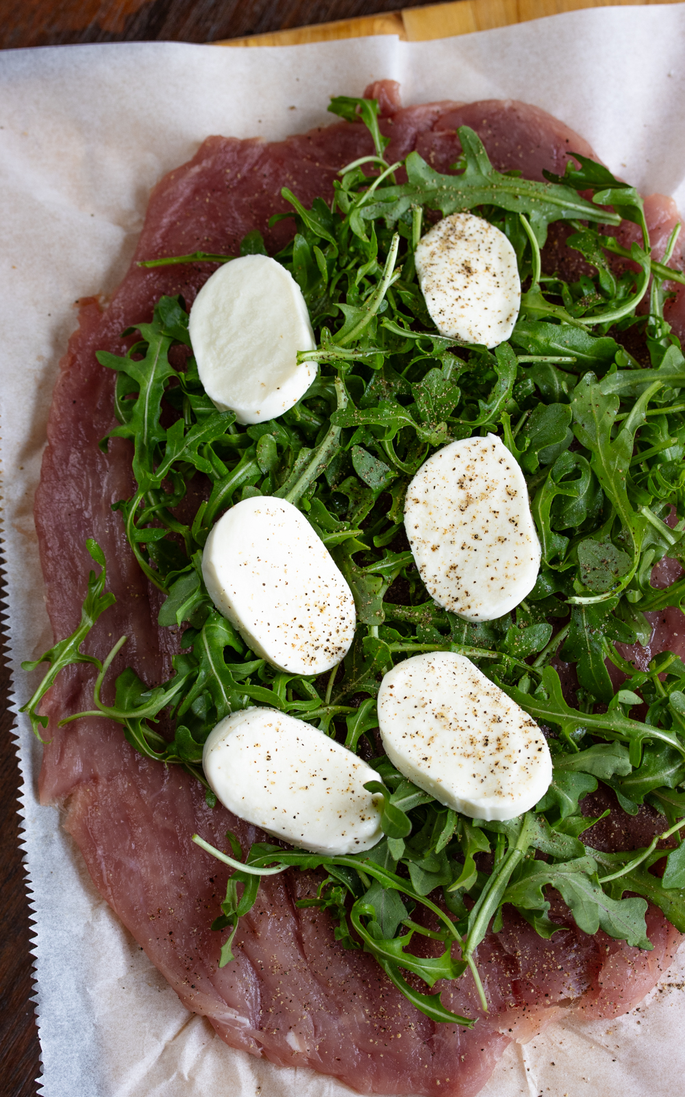 Arranged mozzarella slices over the arugula and sprinkle with salt and pepper.