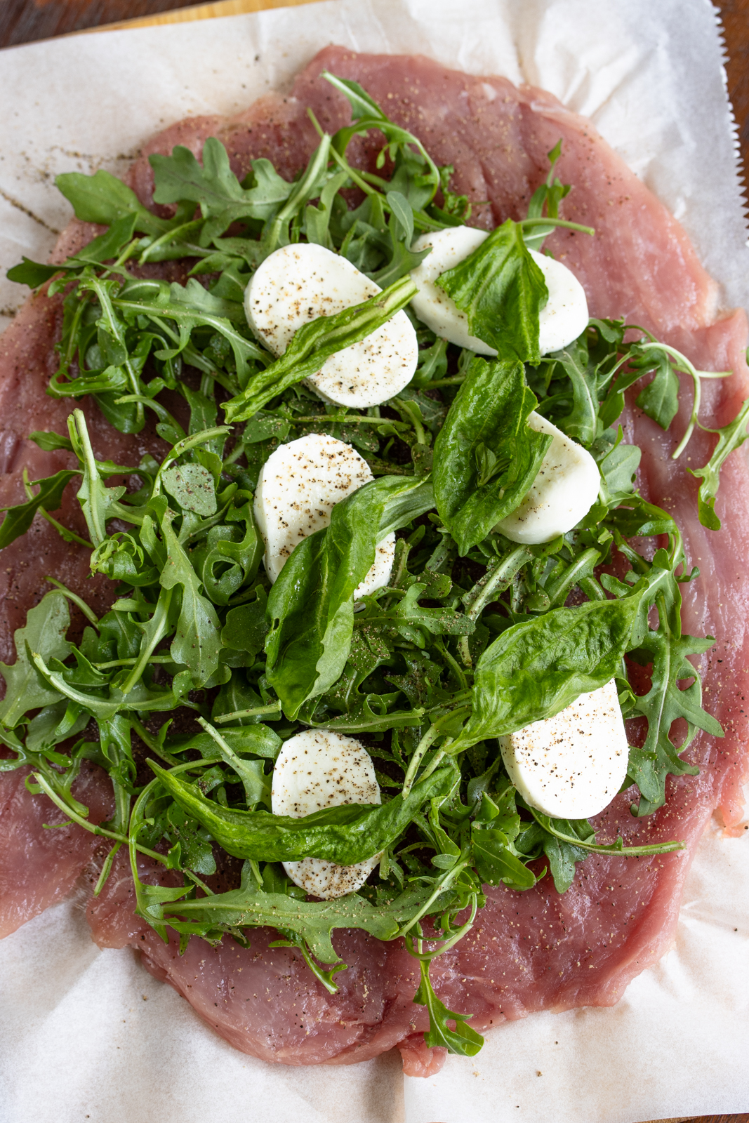 Basil leaves added over the mozzarella and seasoned with salt and pepper.