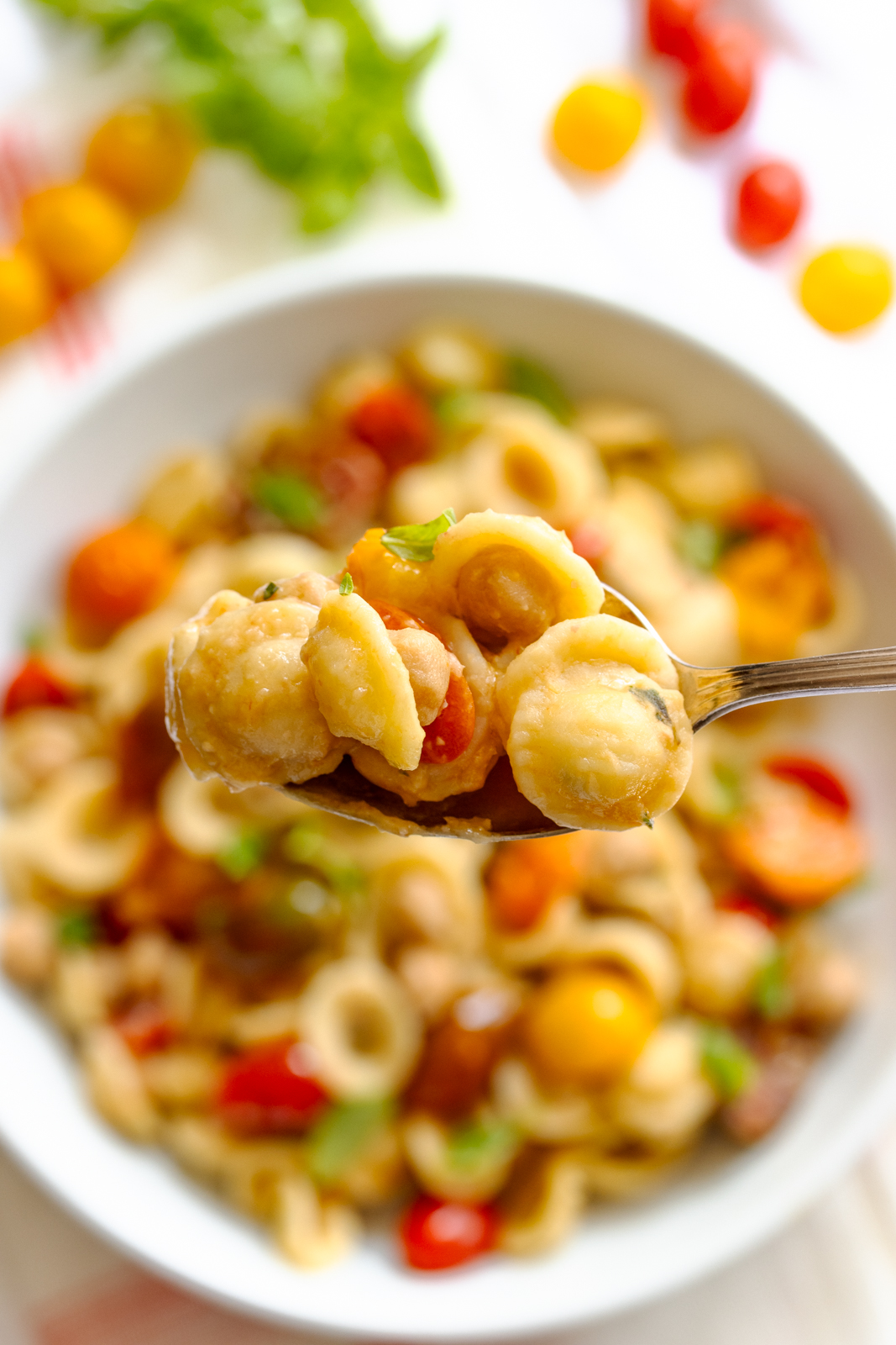 spoonful of orecchiette pasta, chickpeas, and cherry tomatoes