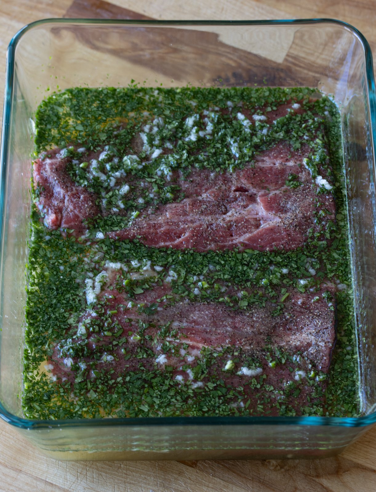 marinating hte steaks into the glass container with the tequila, lime, honey