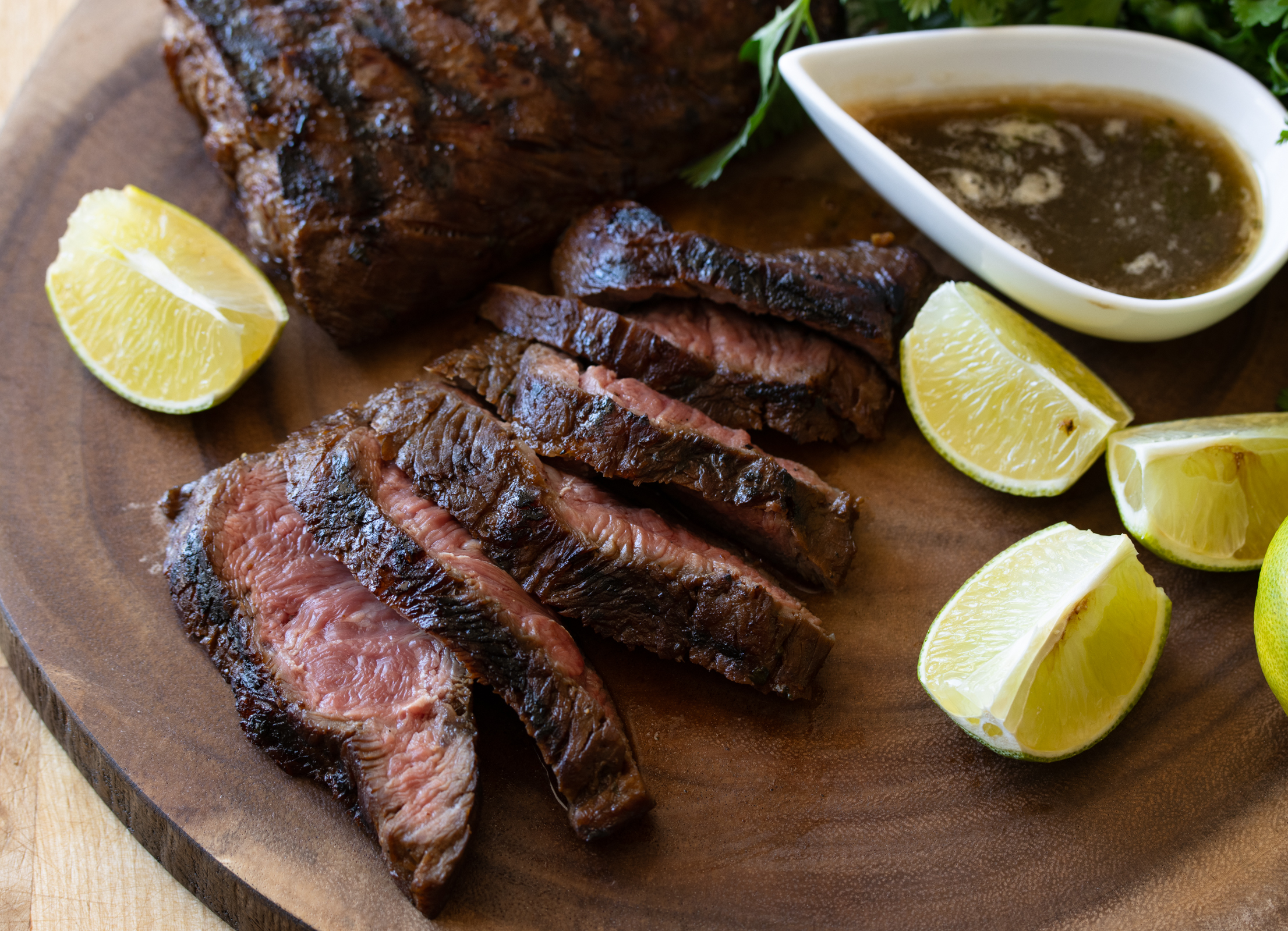 sliced flat iron steak on a wooden cutting board