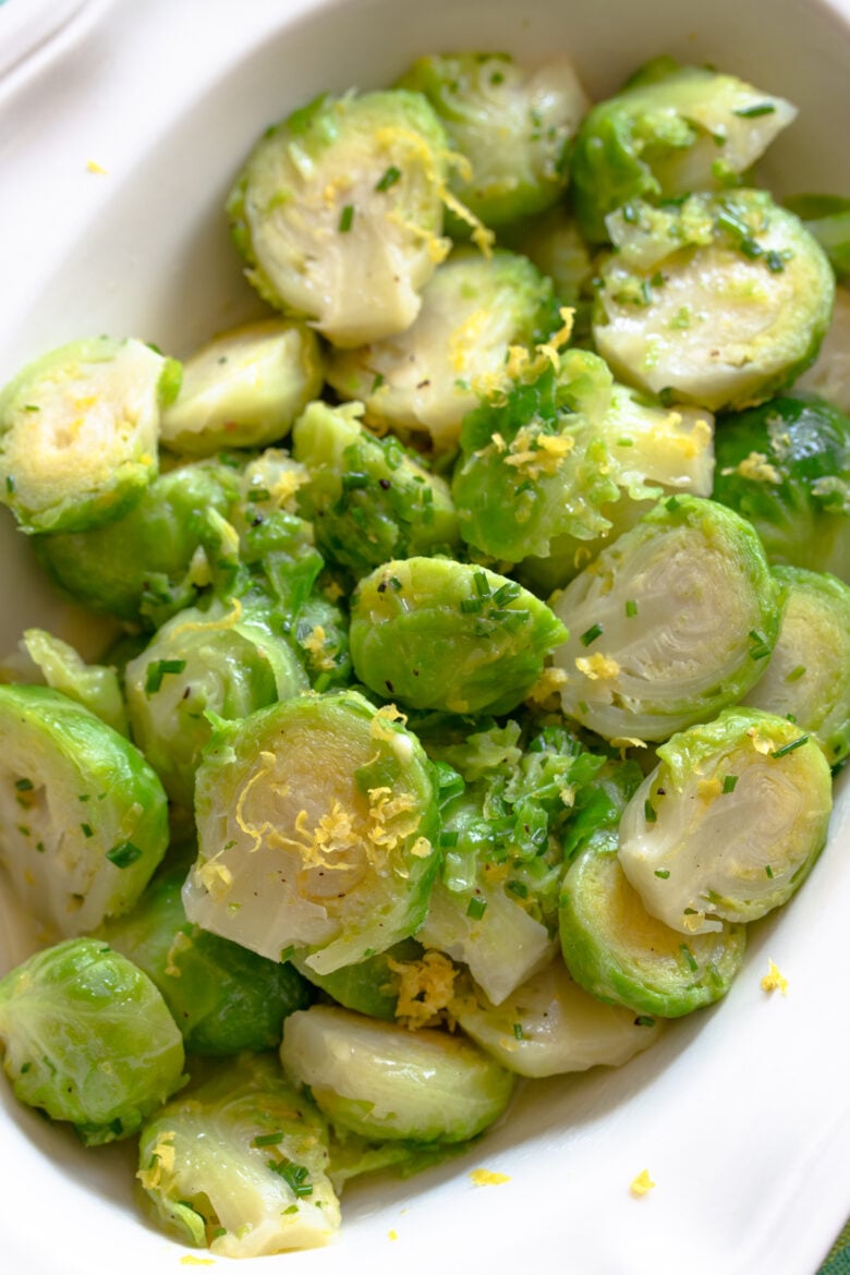 Brussels sprouts with lemon in a white scalloped serving dish