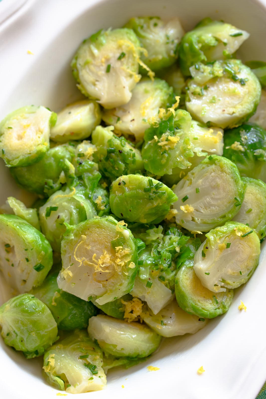 Brussels sprouts with lemon in a white scalloped serving dish