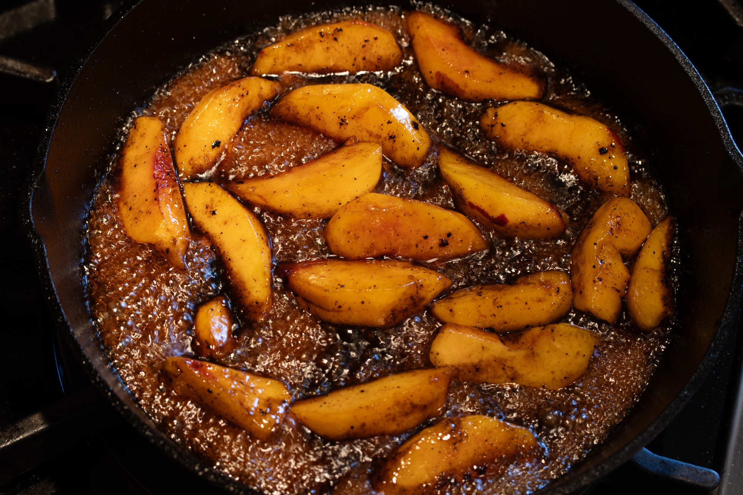 Bubbling peach glaze created by adding the honey, bourbon and balsamic vinegar to the skillet.