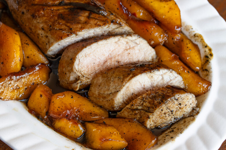 Sliced pork surrounded with peaches. 