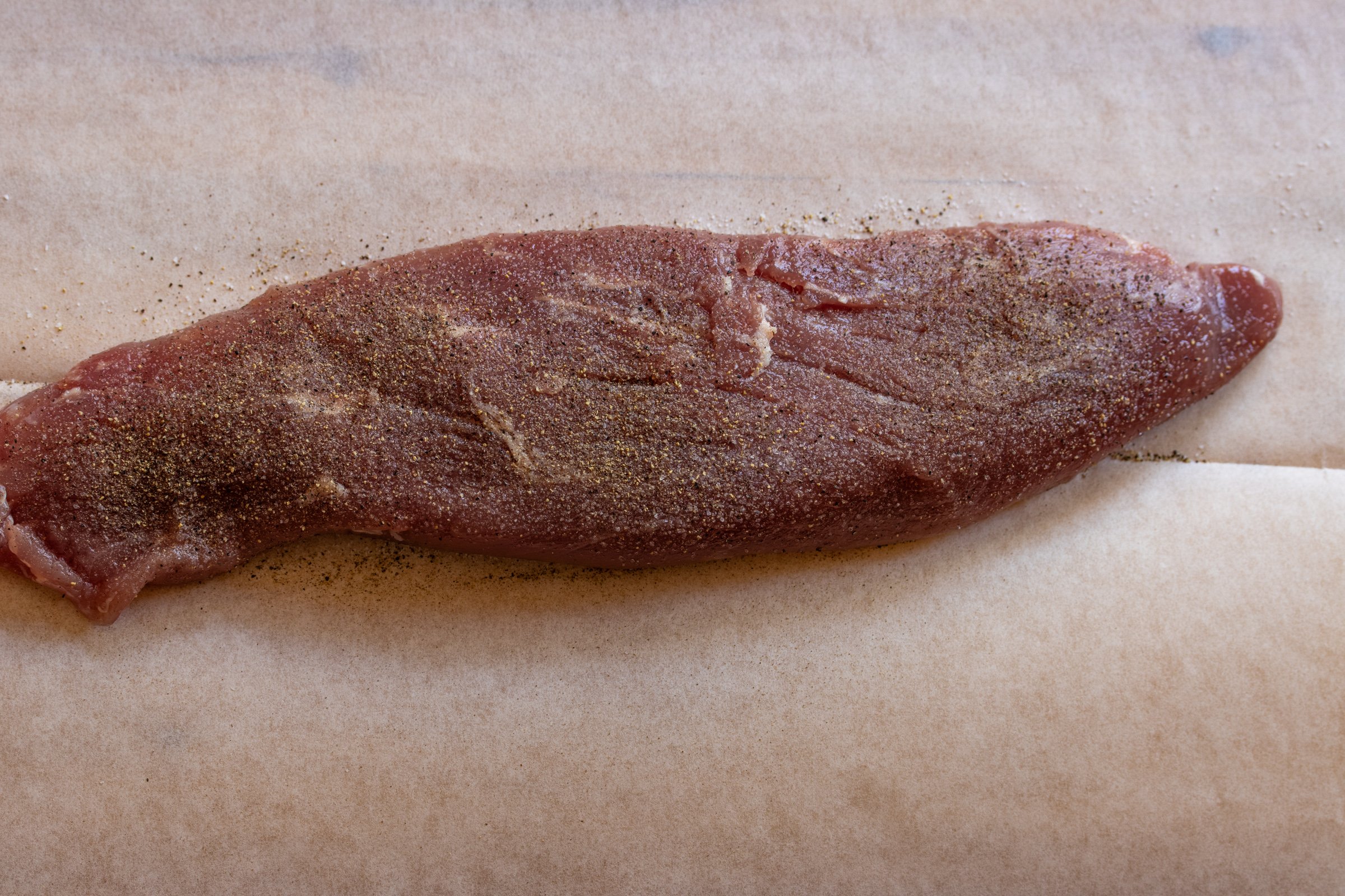 Pork tenderloin seasoned generously with salt and pepper.