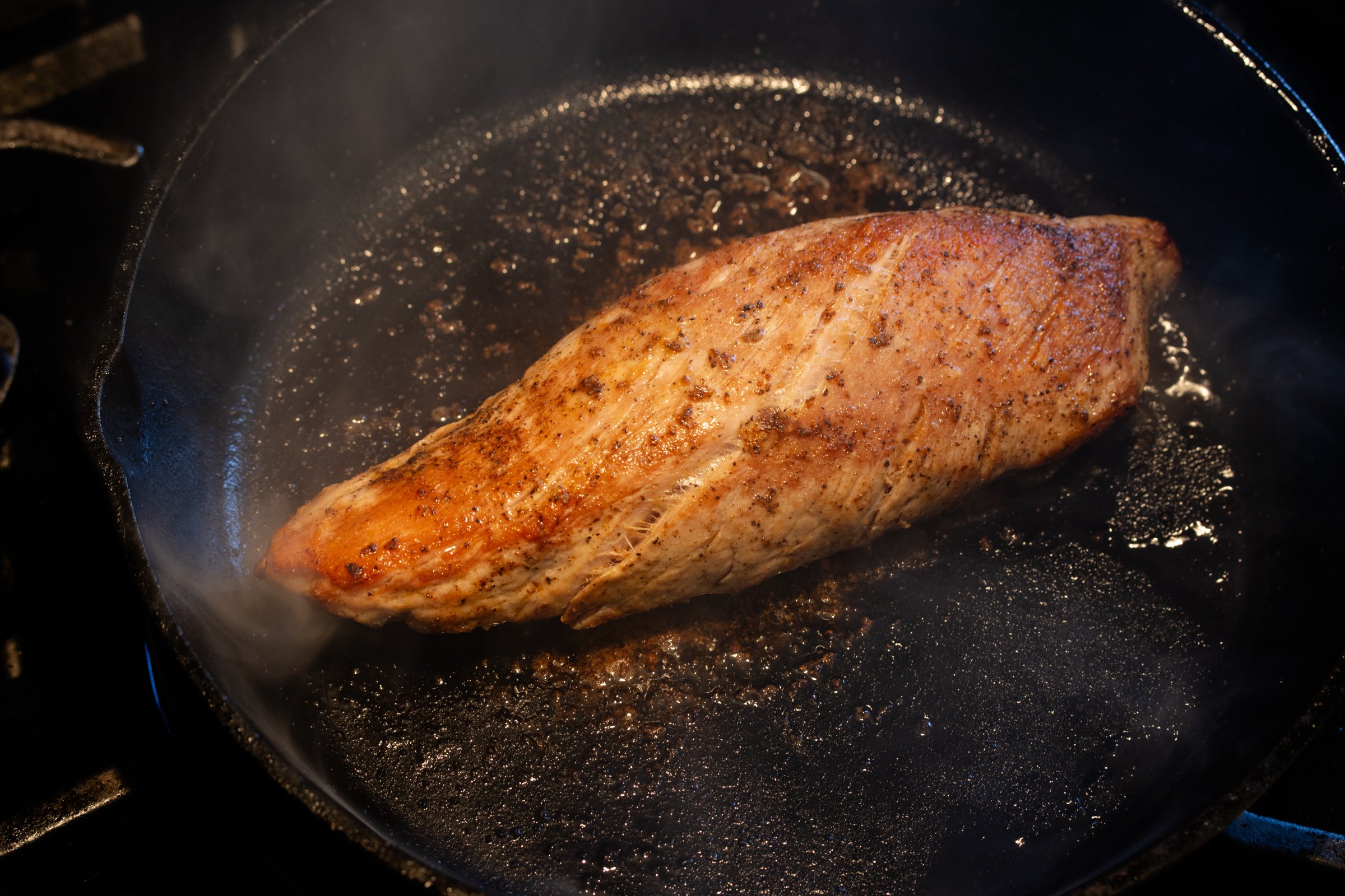 Pork tenderloin fully cooked on all sides in the cast iron skillet.