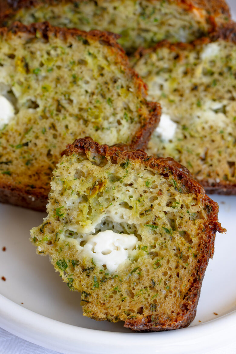 Close up of a slice of herb bread on a white serving plate.