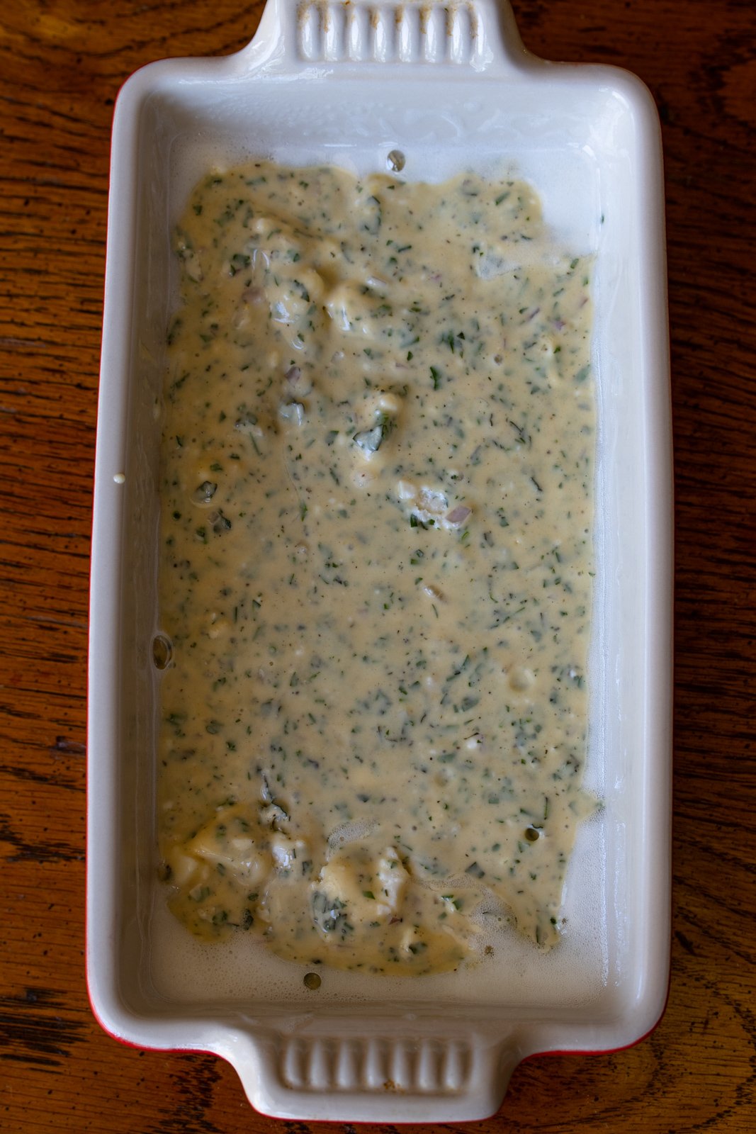 Bread mixture inside teh bread loaf pan ready to be entered in teh oven. 