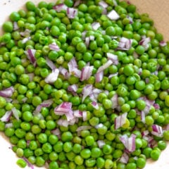 Pea salad served in a off white serving dish.