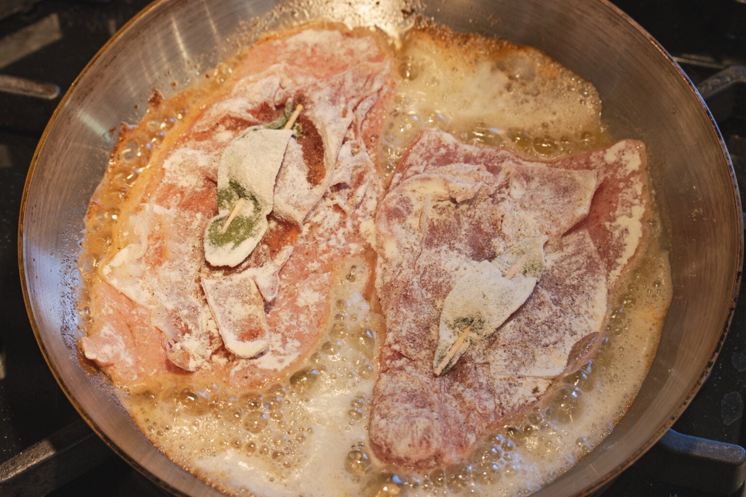 Frying the veal in a skillet with melted butter.