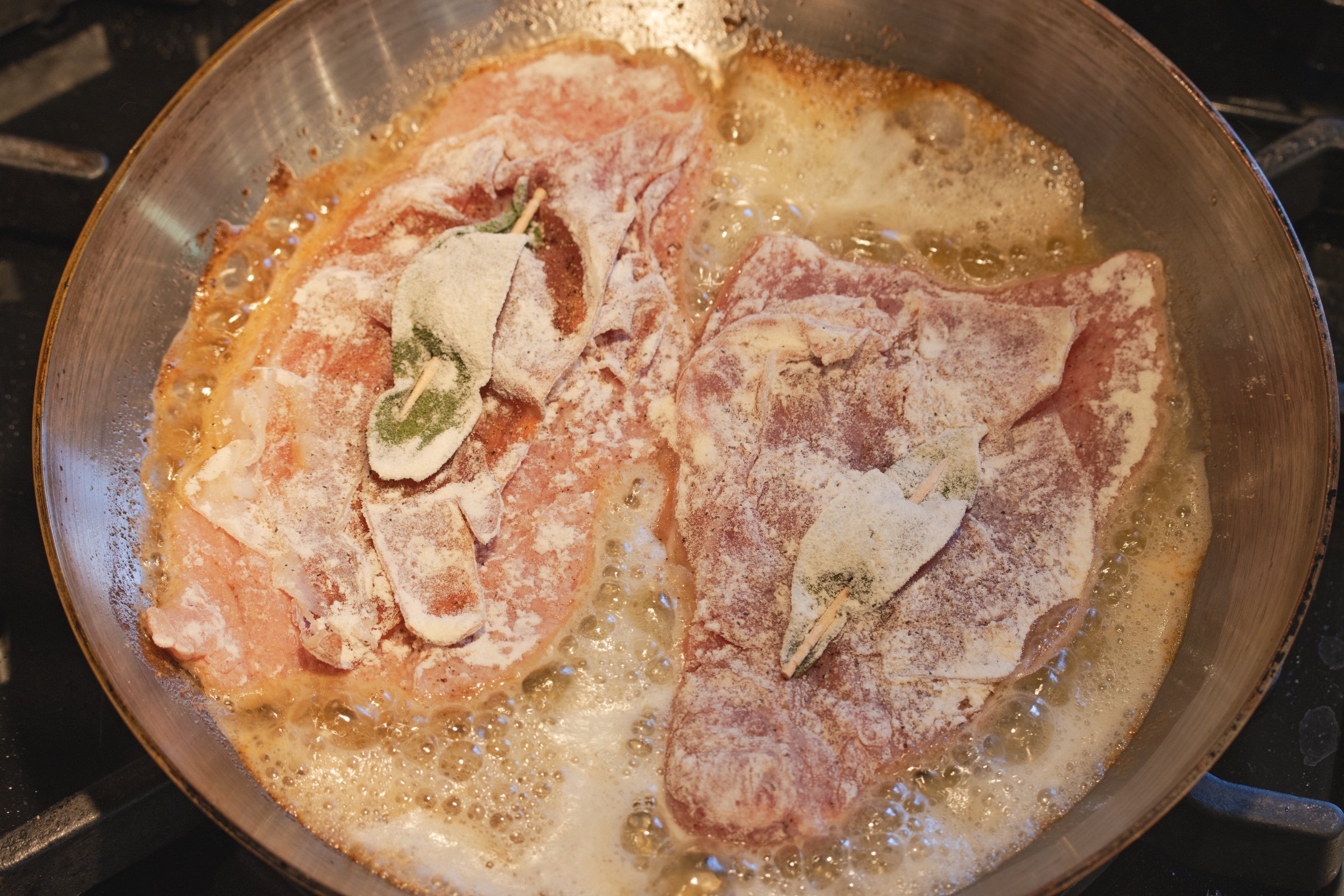 Frying the veal in a skillet with melted butter.