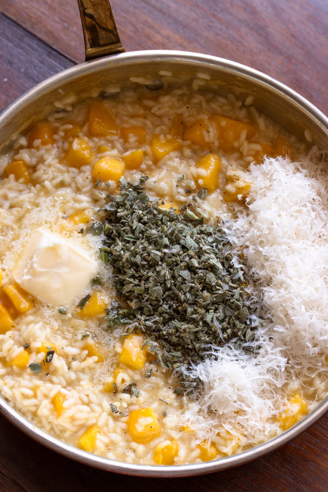 Butter, chopped sage and grated Parmesan cheese added to the finished butternut squahs risotto.