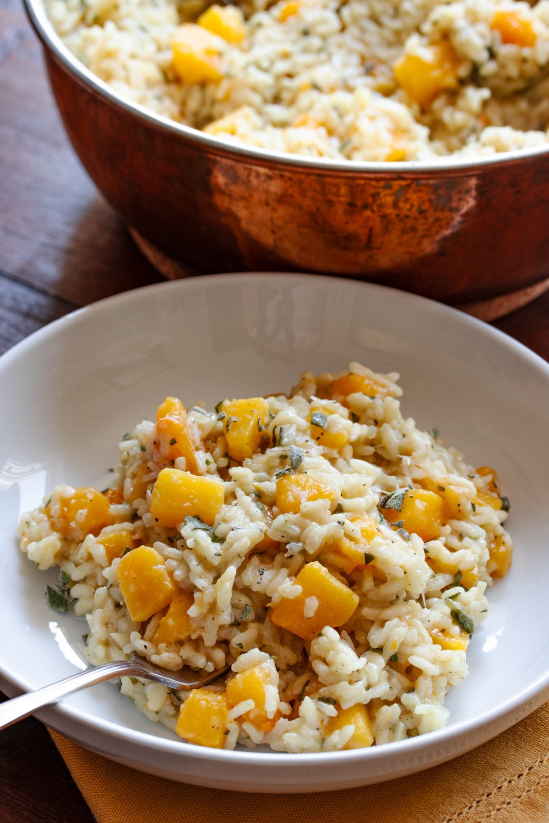 Butternut squash risotto served in white bowls.