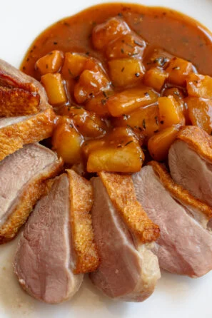 Crispy duck breasts with pear and pepper sauce.