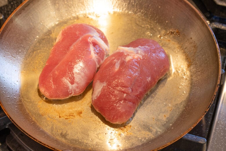 Searing the duck breasts skin side down for 20 minutes. 
