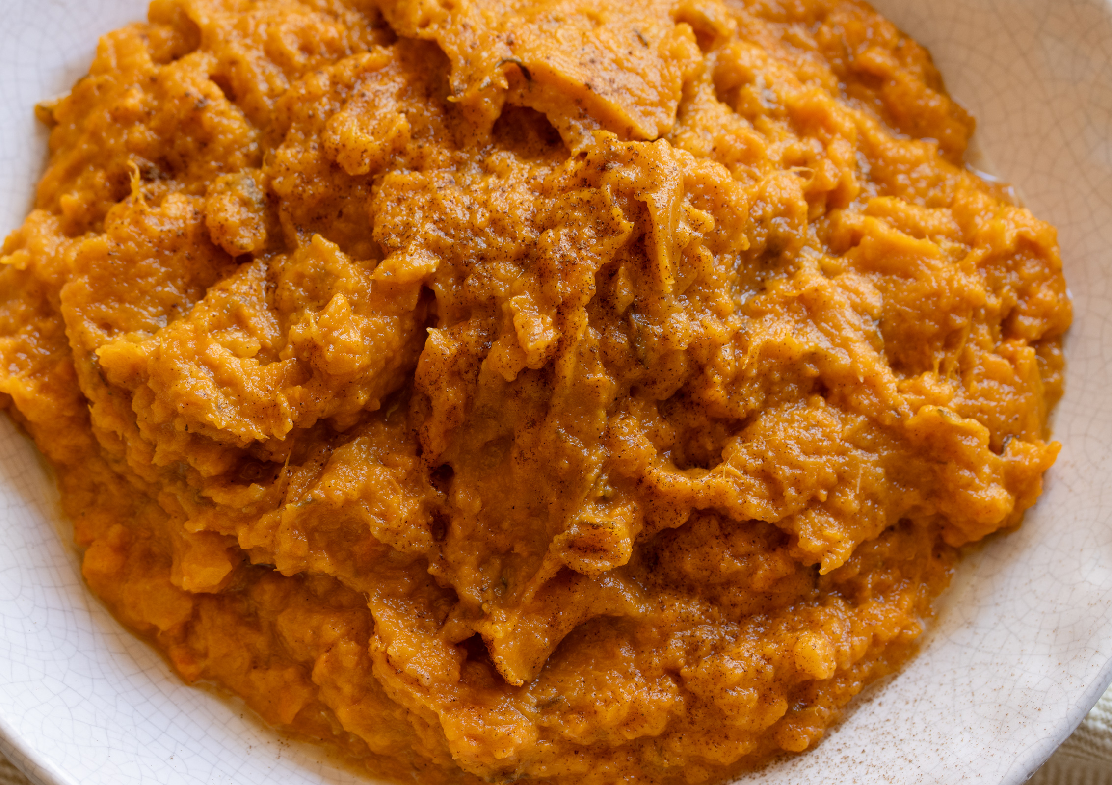 Dash of cinnamon sprinkled over the sweet potatoes ready to be served. 