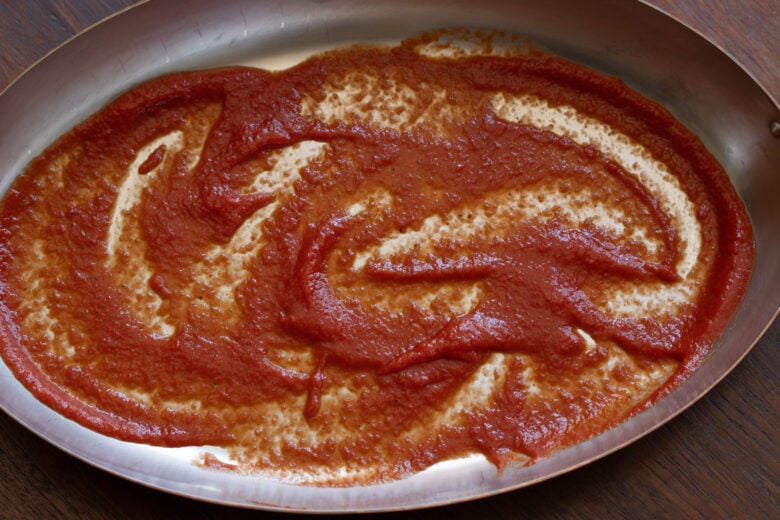 Tomato sauce added to the bottom of a baking dish awaiting the stuffed cannelloni. 